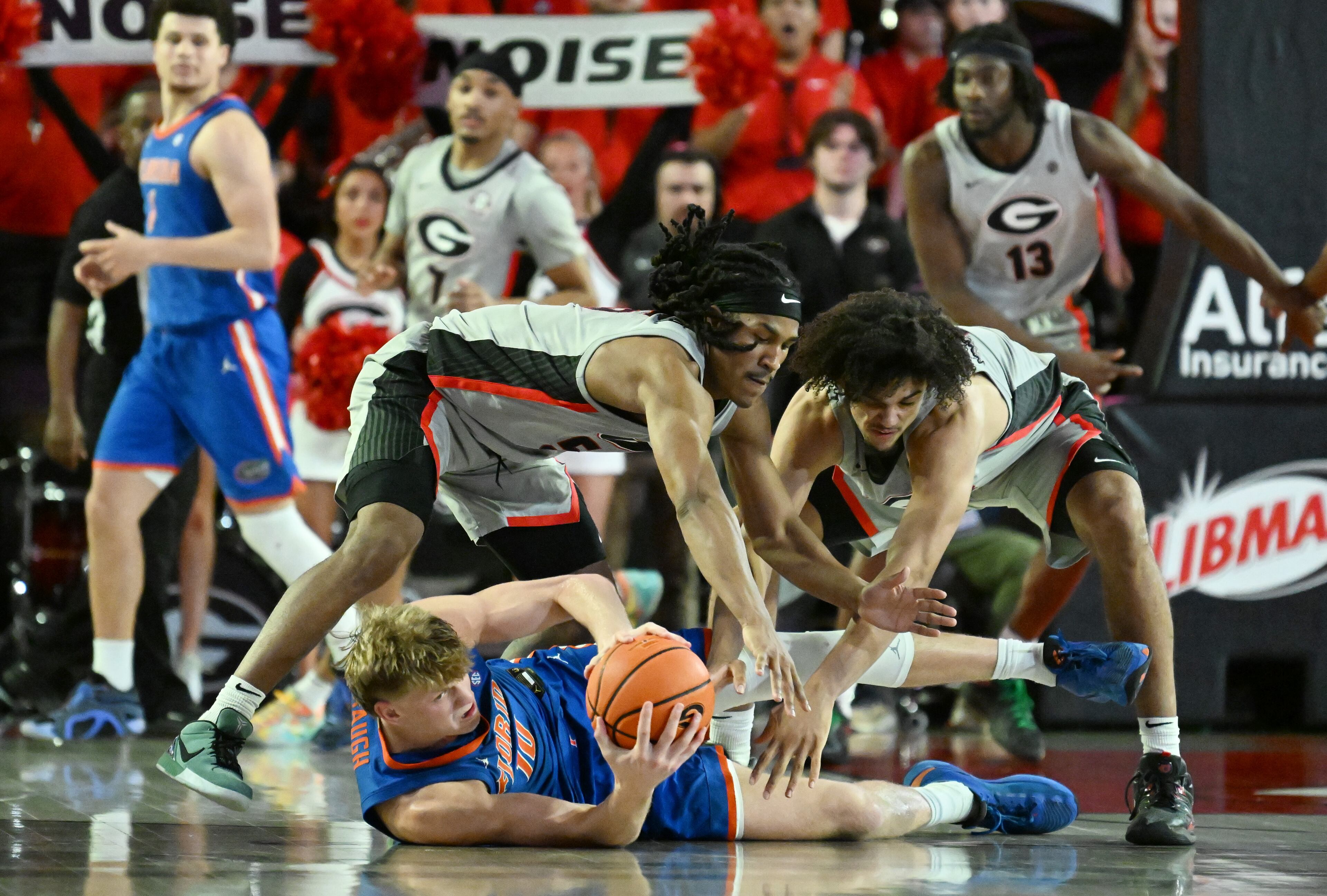 Florida forward Thomas Haugh (10) fights for a loose ball against Georgia guard Silas Demary Jr. (left) and Georgia forward Asa Newell during the second half of an NCAA college basketball game at Stegeman Coliseum, Tuesday, February 25, 2025, in Athens. Georgia won 88-83 over Florida. (Hyosub Shin / AJC)