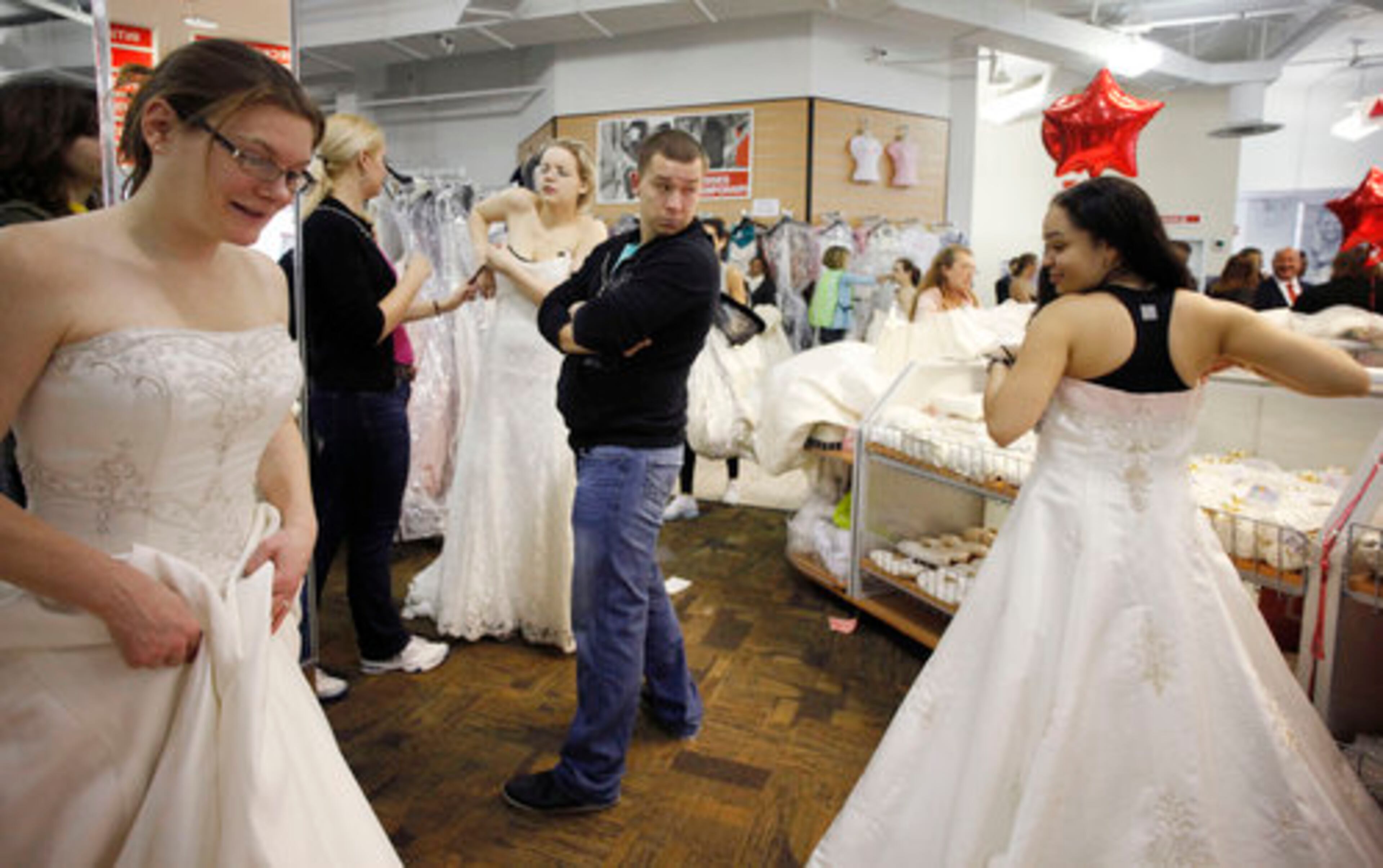 A man watches brides-to-be try on wedding gowns during the "Running of the Brides."