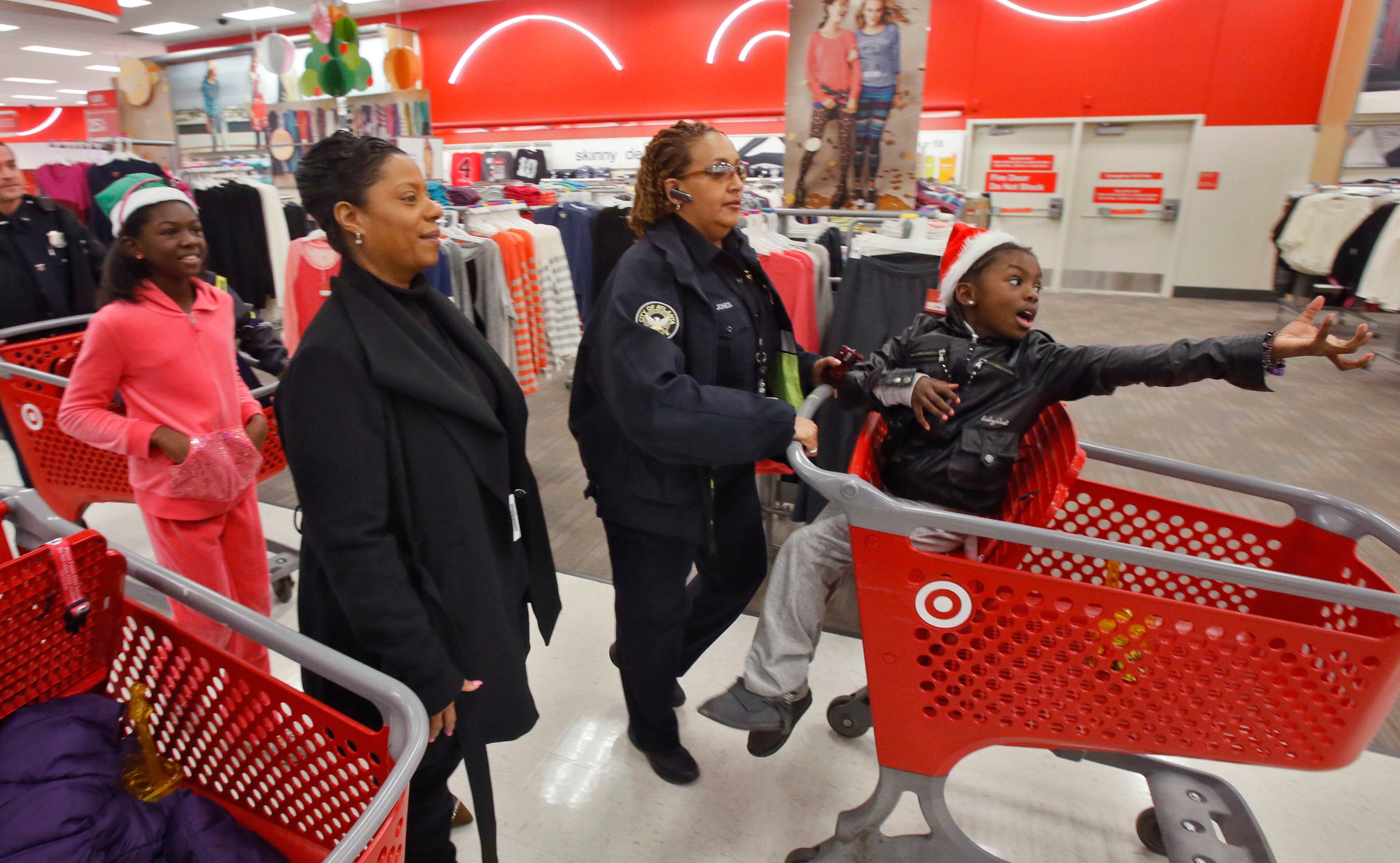 Victoria Smiley (far left) shops with her sister, Elizabeth, and their Santa Cop Shop hosts, Kathy Terry (center left) and Officer Kim Jones. They are children of Officer Shawn A. Smiley, who was killed last year in a helicopter crash while search for a missing 9-year-old boy. The International Brotherhood of Police Officers hosted its annual “Santa Cop” Thursday. Atlanta Police Officers and children shopped for gifts at the Atlantic Station Target store after breakfast at the Hard Rock Cafe. Most of the children involved with this event would not have a Christmas if this event were not held.