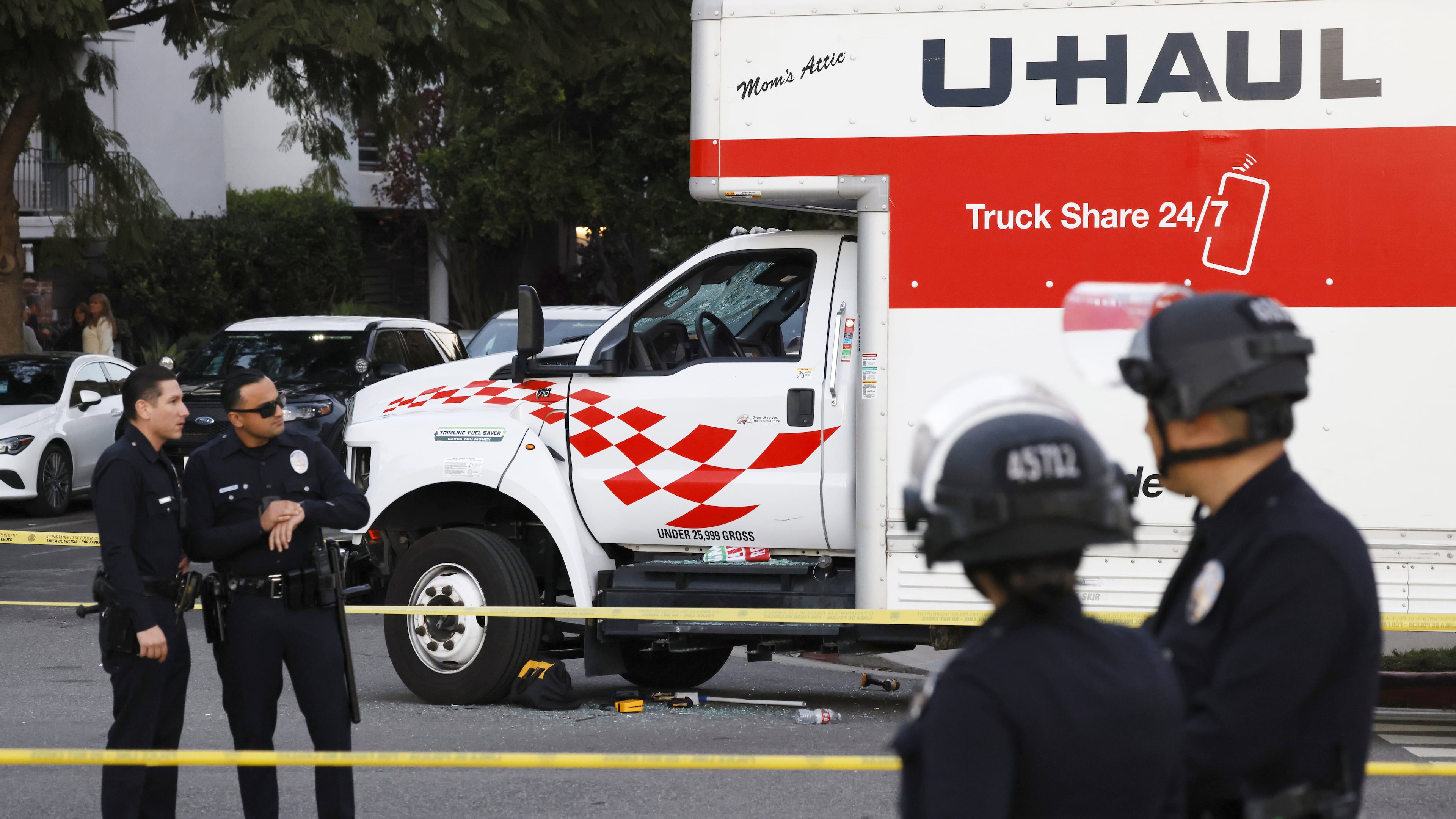 A U-Haul truck, which was driven into a group of protesters, is surrounded by LAPD officers after the incident on Jan. 11, 2026, in the Westwood section of Los Angeles. (Kayla Bartkowski/Los Angeles Times via AP)