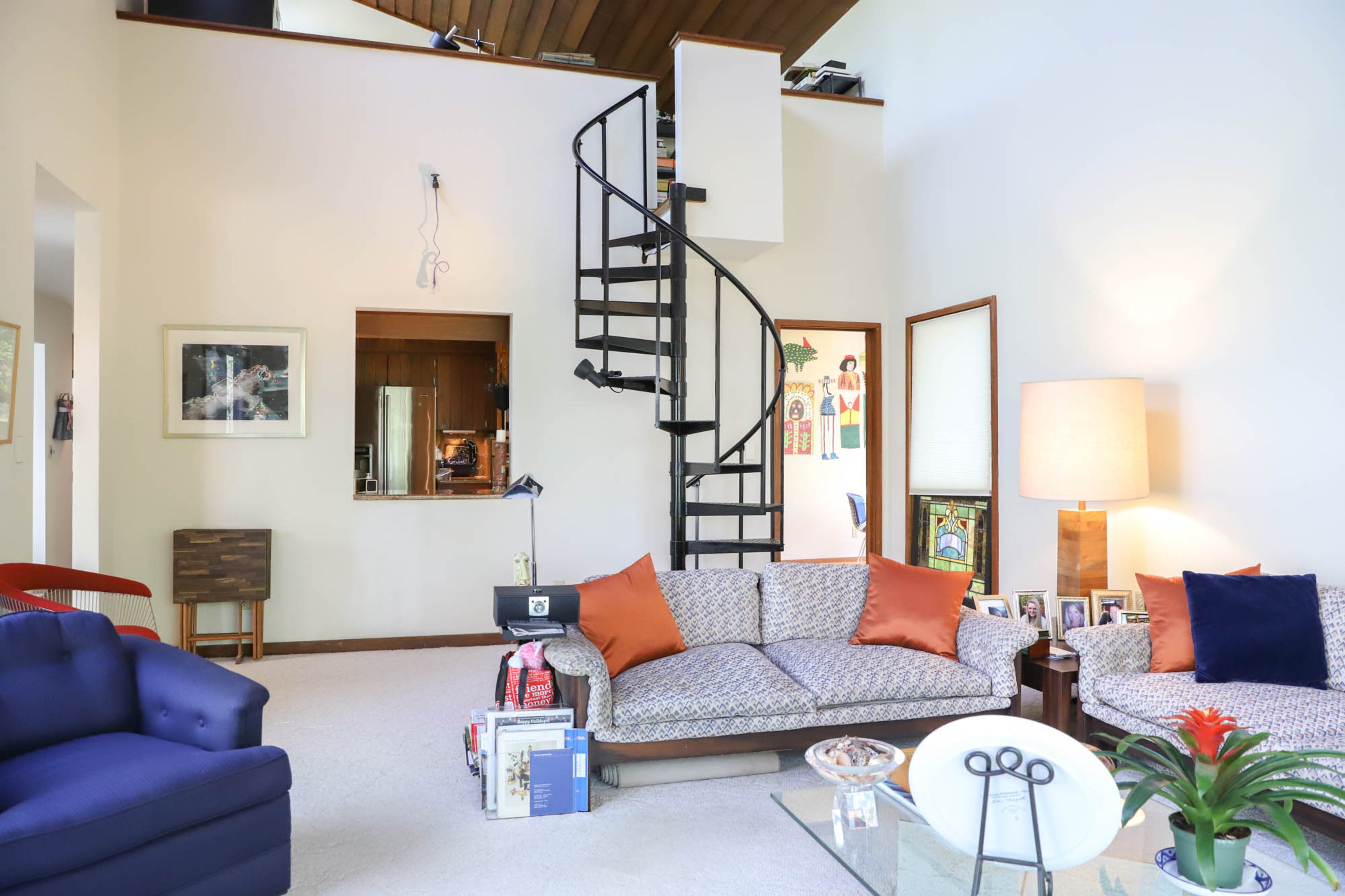 A spiral staircase leads up to Carol Muldawer’s photography studio in Carol and Paul Muldawer’s Fulton County home. The couple uses this space casually, for watching TV and relaxing. The den, living room and dining room of their home have high redwood ceilings and skylights that fill the home with light and space. Text by Shannon Dominy/Photo by Reynolds Rogers