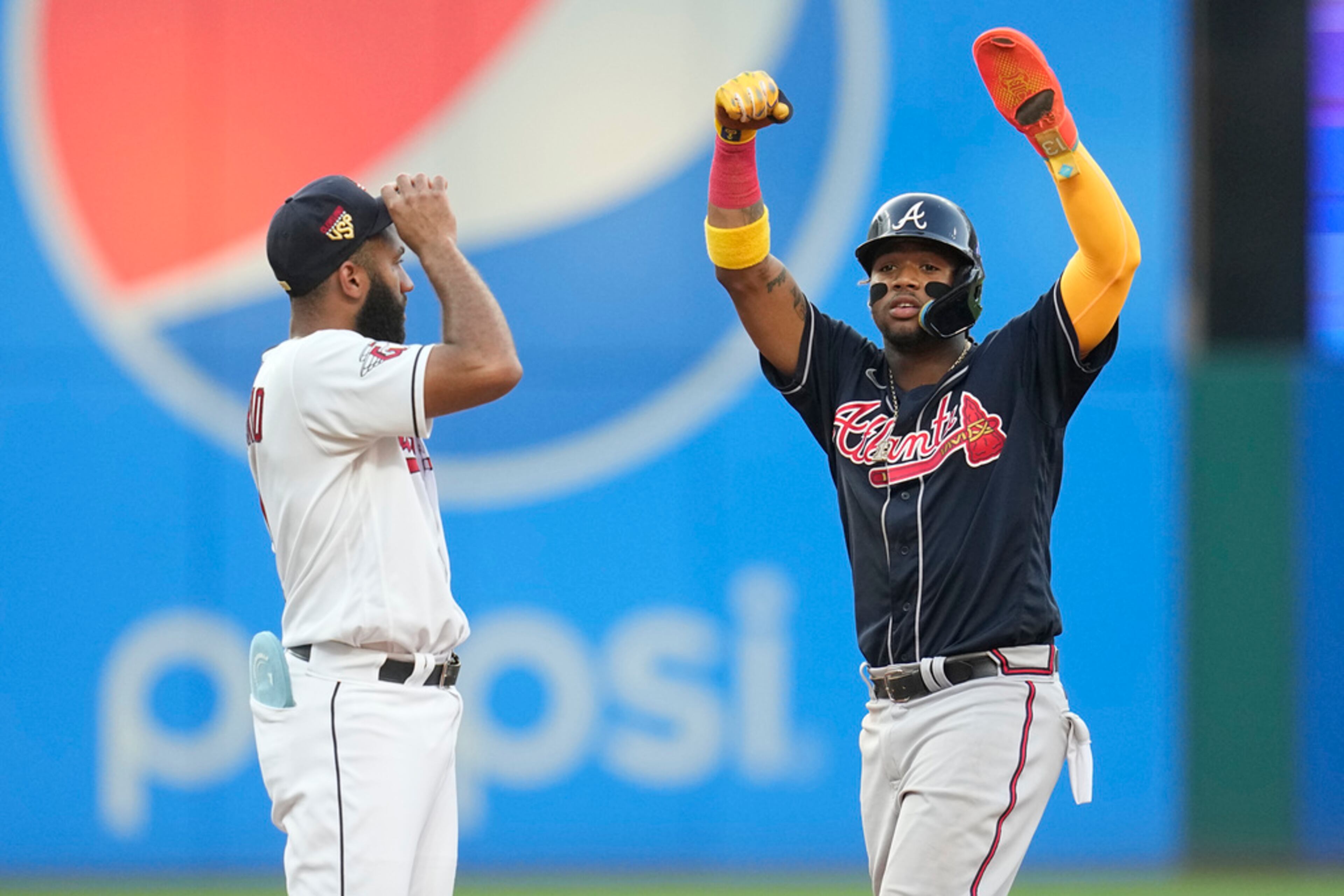 Atlanta Braves' Ronald Acuna Jr. gestures at second base in front of Cleveland Guardians shortstop Amed Rosario, left, after stealing second during the fifth inning of a baseball game Tuesday, July 4, 2023, in Cleveland. (AP Photo/Sue Ogrocki)