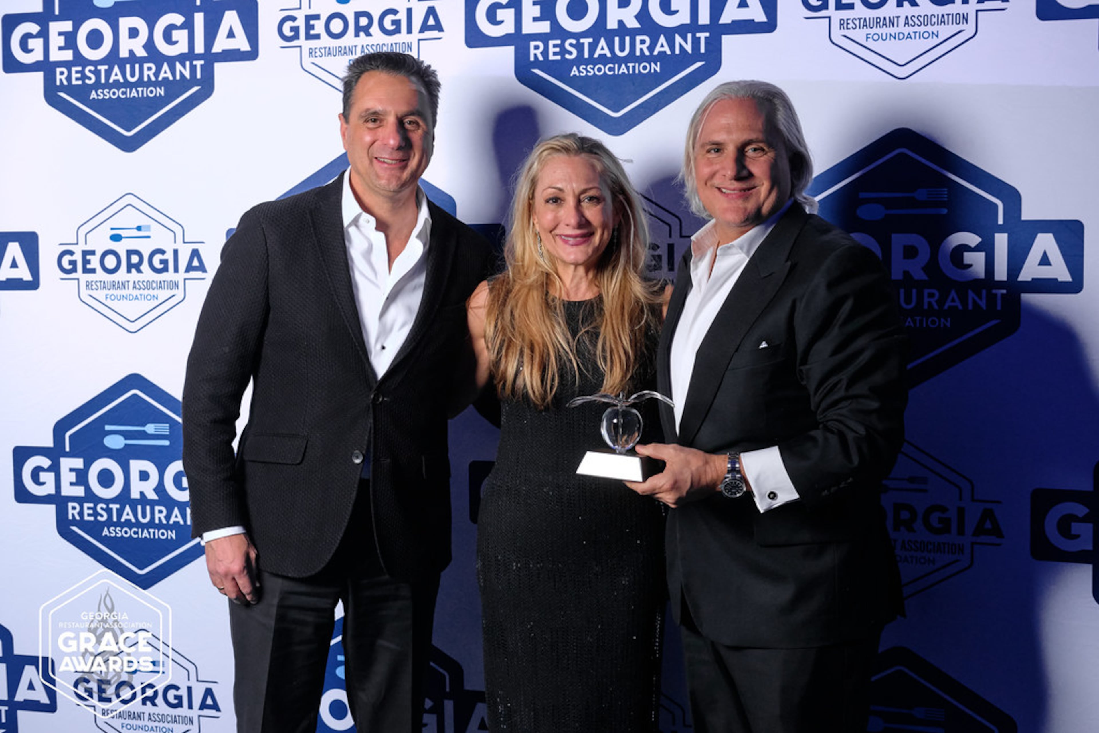 Niko Karatassos (left), Anne Symbas (center) and Pano I. Karatassos (right) attended the Georgia Restaurant Association Crystal of Excellence Awards to represent their father, I. Pano Karatassos of Buckhead Life Group, during his induction into the hall of fame. (Courtesy of Georgia Restaurant Association)