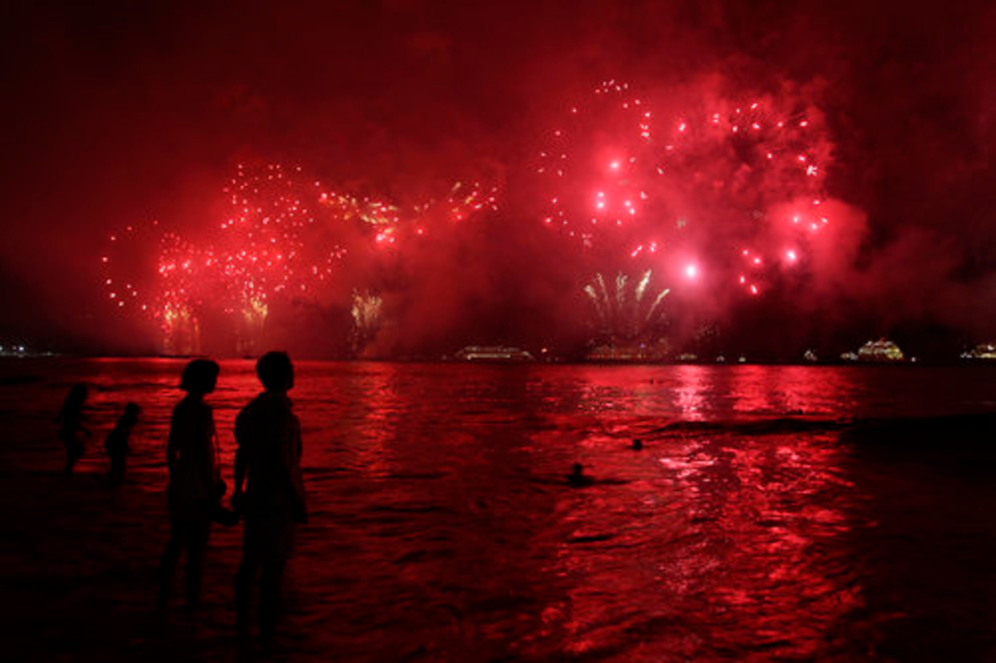 People watch fireworks exploding over Copacabana beach during New Year celebrations in Rio de Janeiro, Brazil, Saturday, Jan. 1, 2010.