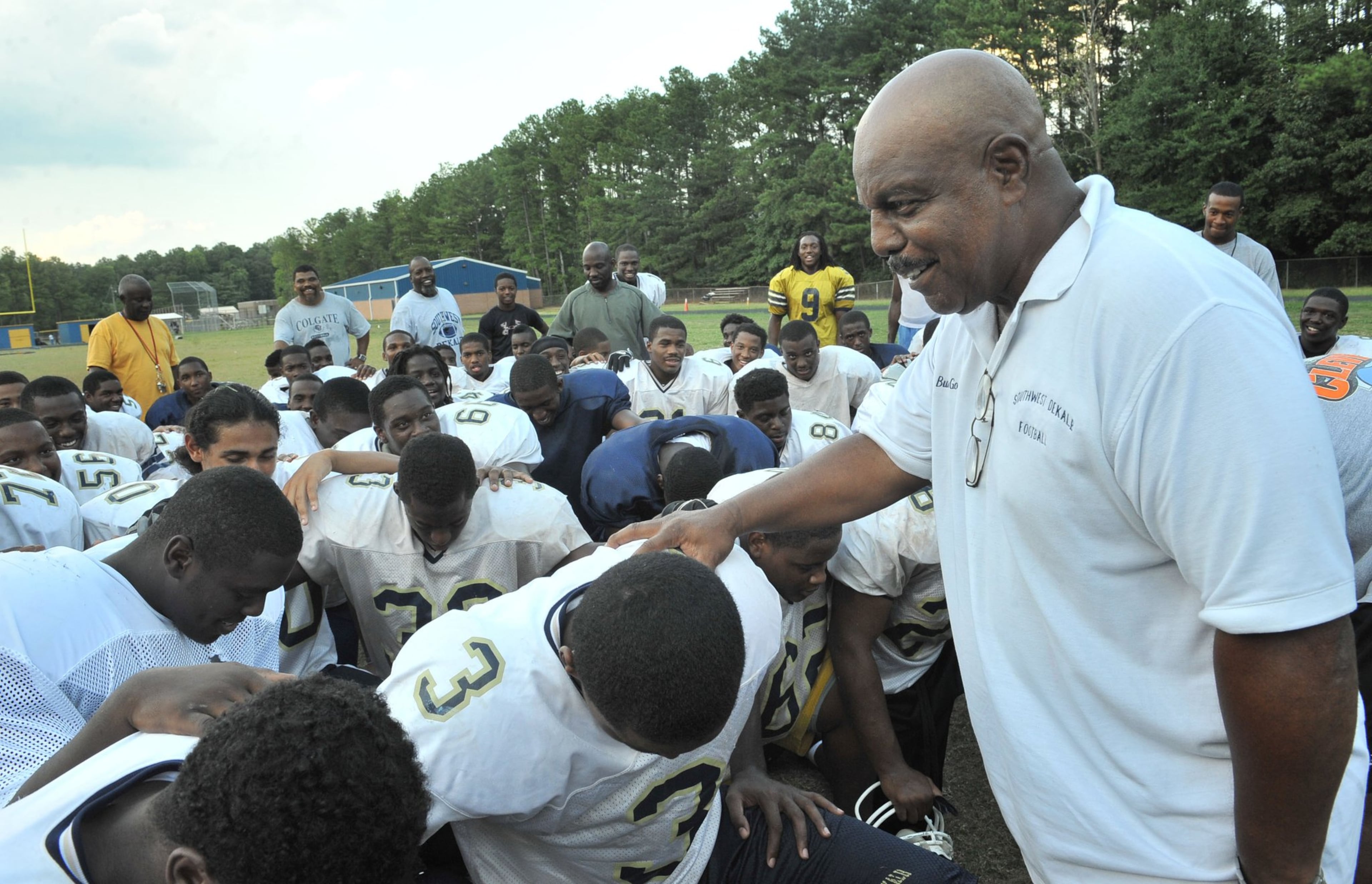 Southwest DeKalb football coach Buck Godfrey (left) talks with his players before dismissing them before a practice in 2009. Hyosub Shin, hshin@ajc.com