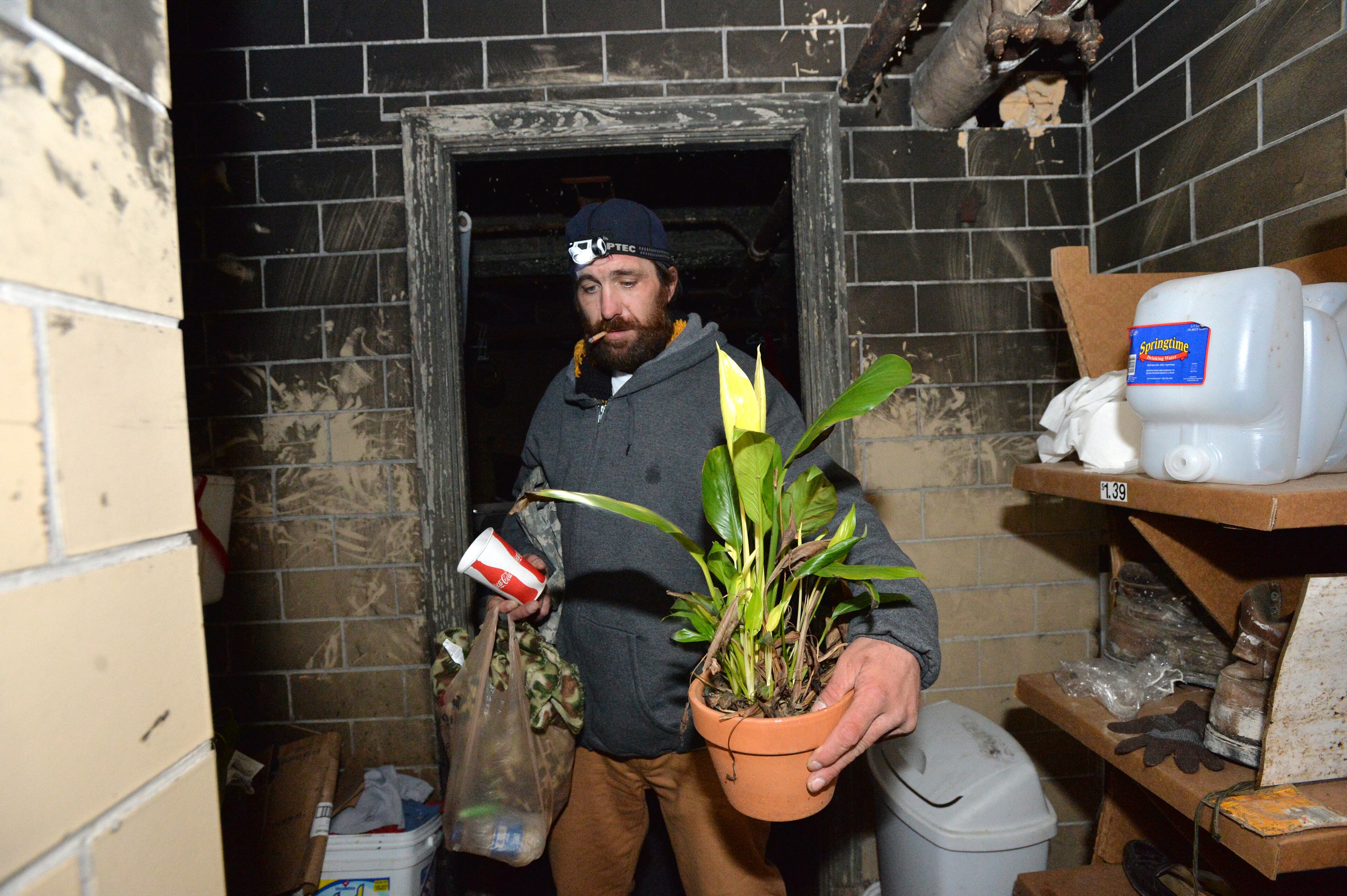 Joel Hartman, the homeless man now staying at the Omni Hotel at CNN Center, holds a plant of his follow homeless as he visits his place he uses to sleep in downtown Atlanta on Saturday, November 23, 2013. Hartman's hotel room is among the rewards he's received for tracking down the owner of a wallet he found while digging through the trash for food. The wallet's owner was a guest at the Omni. When Hartman gave the wallet to Omni security guards, he didn't give them any information on how he could be reached. He simply went back out onto the streets. So Omni staffers went looking for him and put the word out that they considered him a hero. Hartman, who has been homeless since March, said he thought of only one thing when he found the stolen wallet, which contained a credit card: Giving it back.