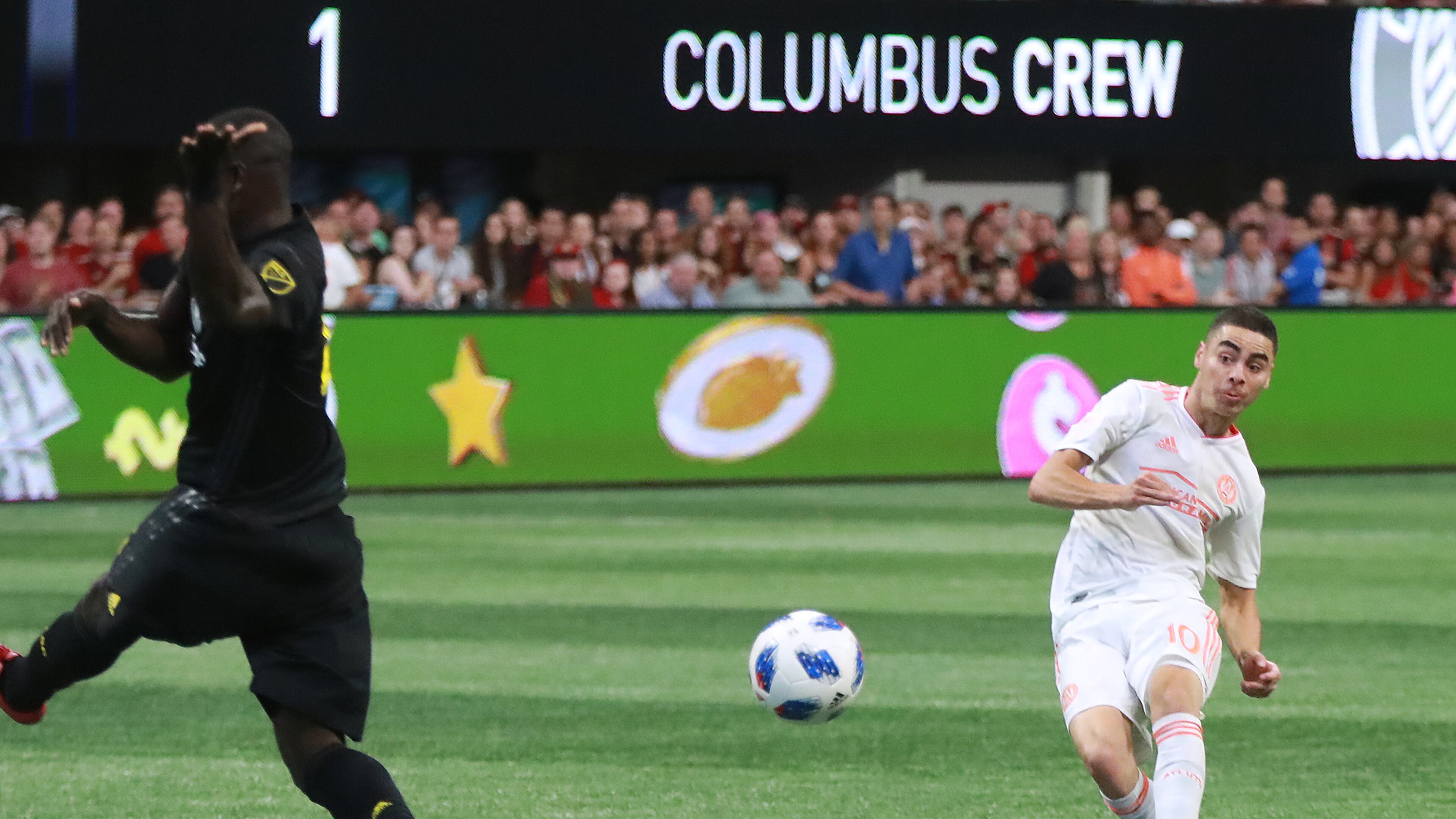 Atlanta United midfielder Miguel Almiron scores a goal past Columbus Crew defender Jonathan Mensah for a 3-1 victory during the second half in a MLS soccer match on Sunday, August 19, 2018, in Atlanta. Curtis Compton/ccompton@ajc.com