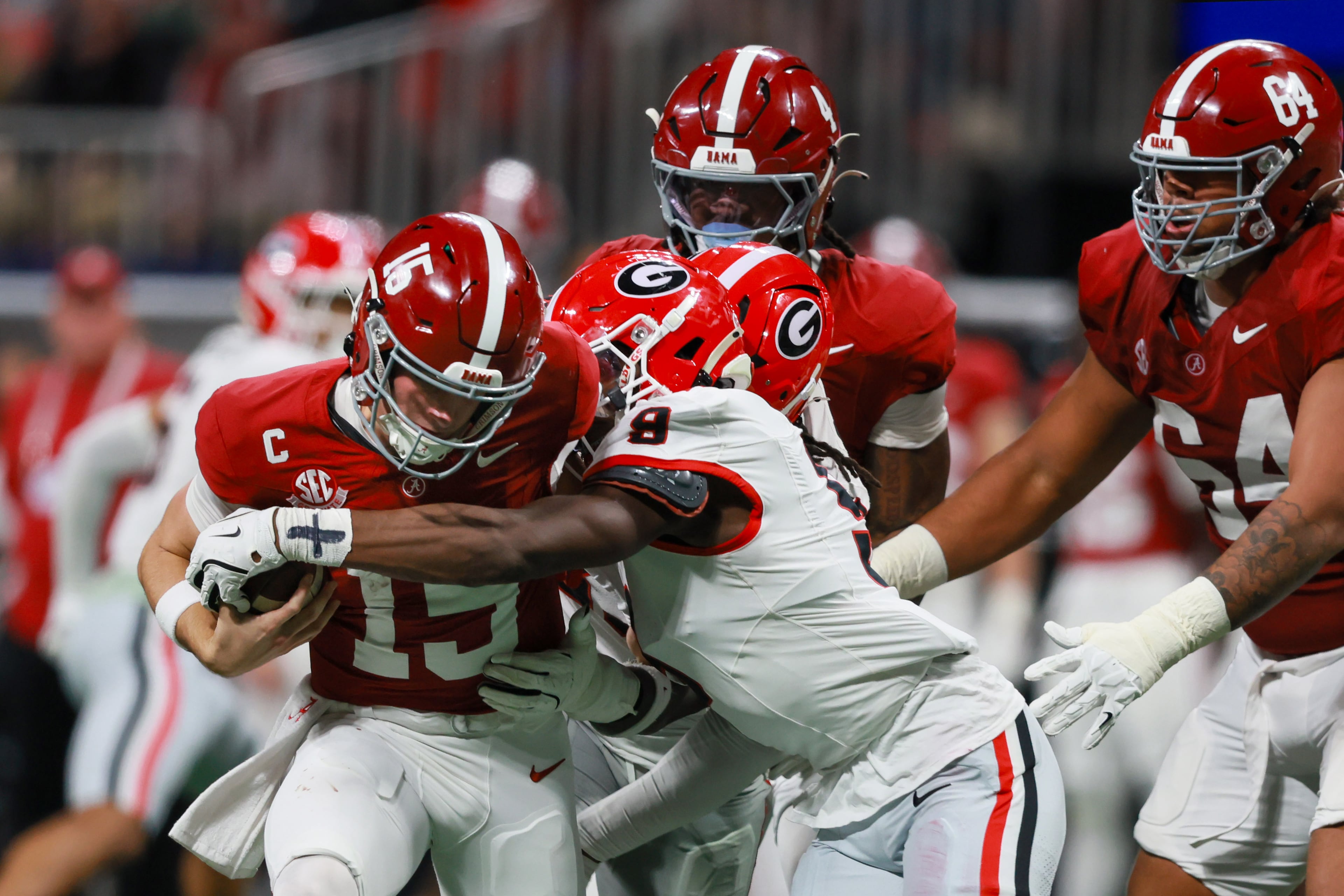 Georgia linebackers Chris Cole (9) and Quintavius Johnson (33) tackle Alabama quarterback Ty Simpson (15) during the fourth quarter of the SEC Championship game at Mercedes-Benz Stadium, Saturday, Dec. 6, 2025, in Atlanta. (Jason Getz / AJC)
