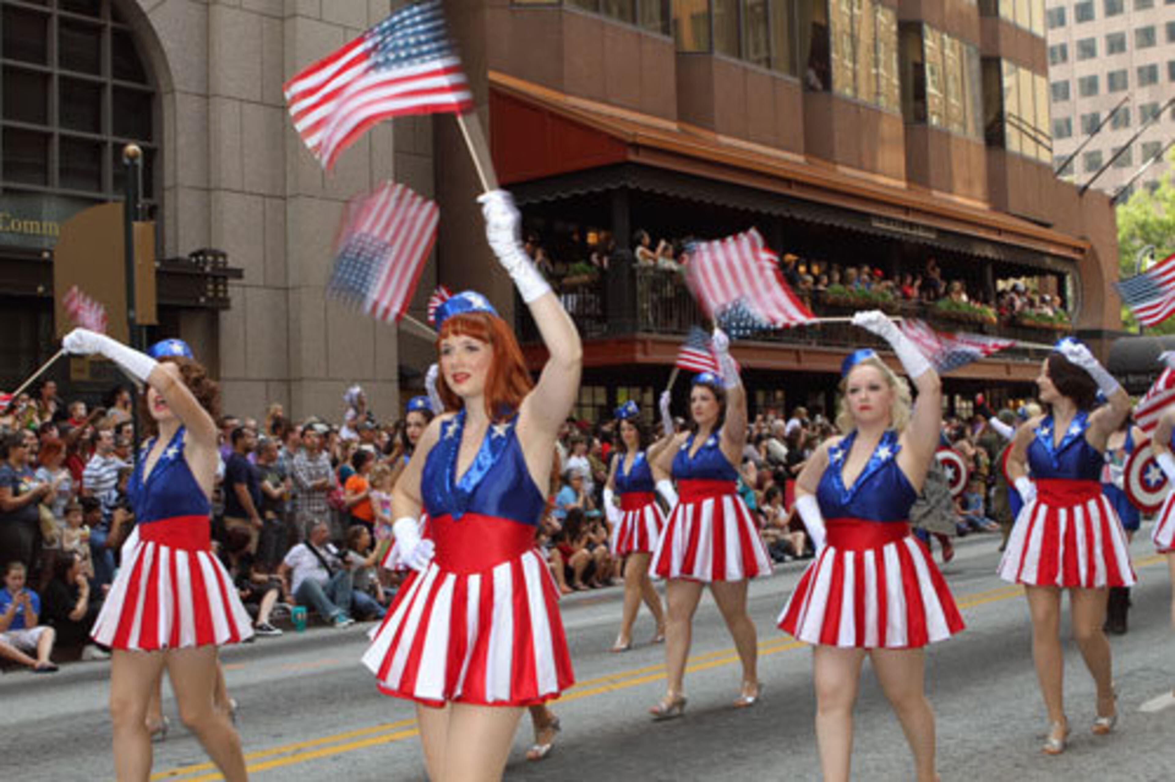 Patriotic flag wavers walk in the downtown parade.
