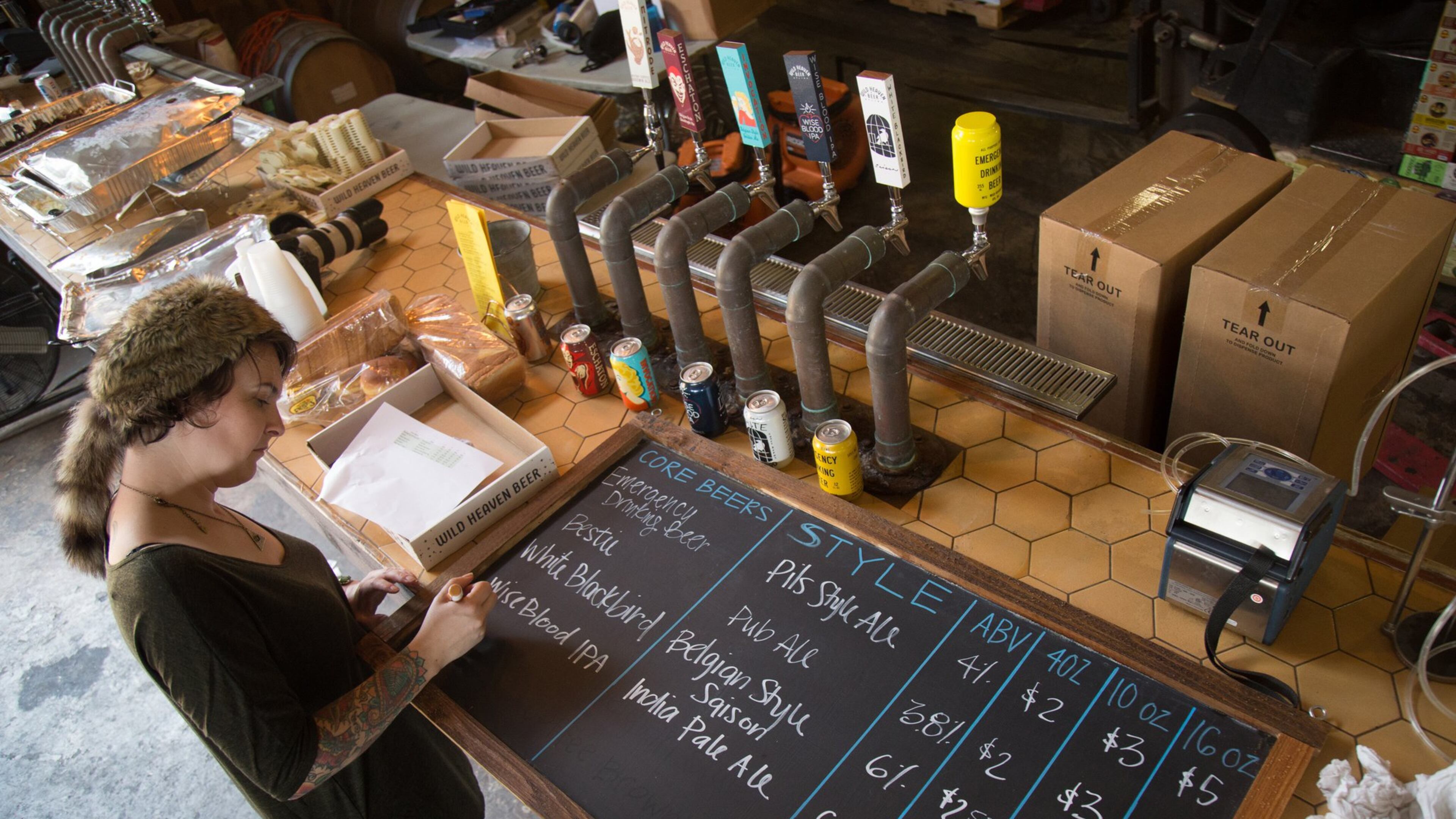 Angela Riley, brand manager at Wild Beer Heaven Brewery, works on a new beer menu in preparation for Friday, when the brewery will be allowed to sell beer directly to customers. STEVE SCHAEFER / SPECIAL TO THE AJC
