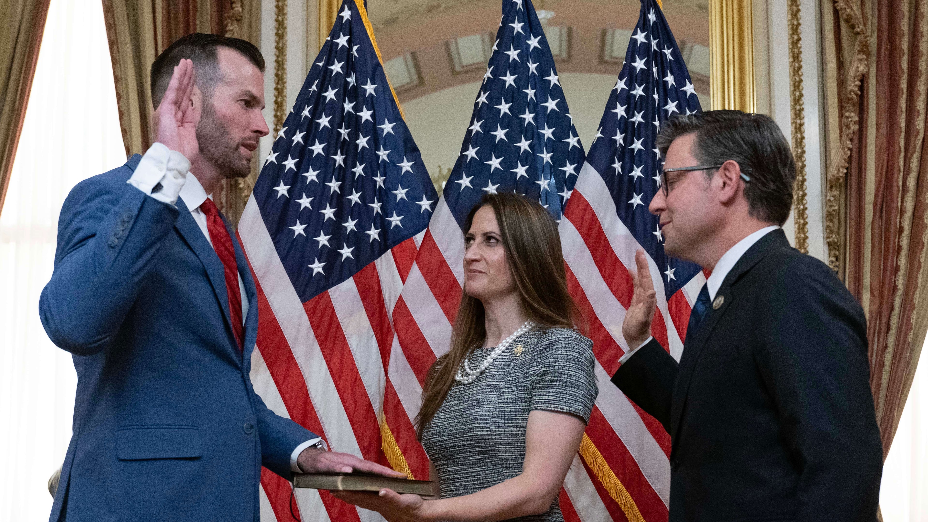 Speaker of the House Mike Johnson, R-La., right, administers the House oath of office to Rep. Clay Fuller, R-Ga., during a ceremonial swearing-in on Capitol Hill in Washington, Tuesday, April 14, 2026. Kate Fuller holds the Bible.( AP Photo/Jose Luis Magana)