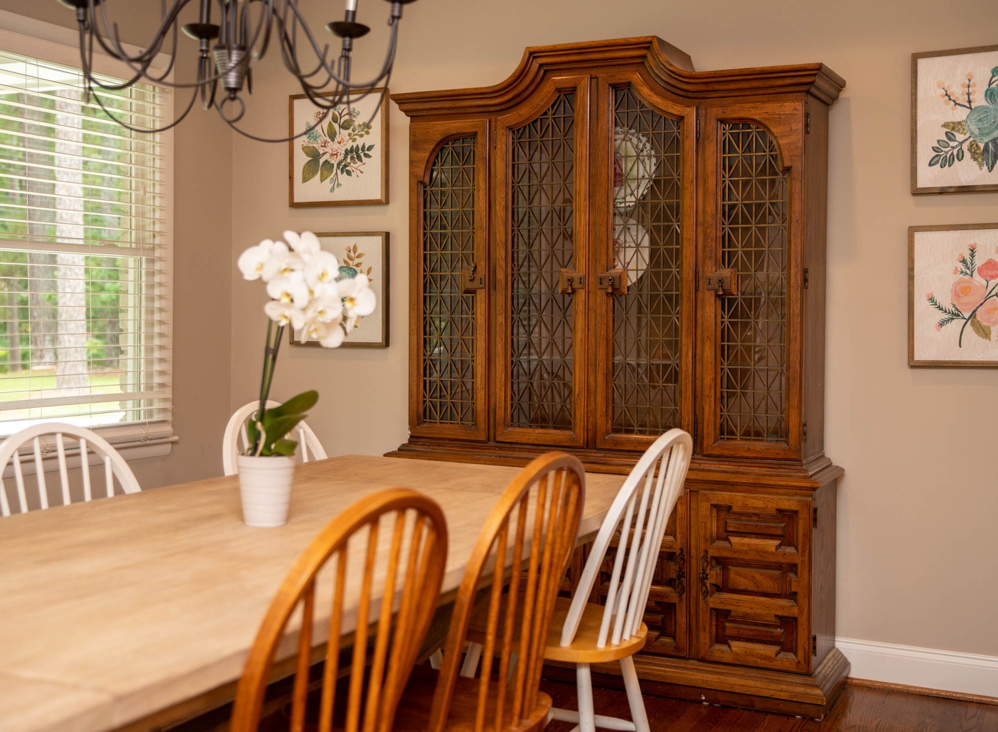 An orchid sits as a centerpiece on the Pottery Barn table in Allie and Seth Ott's dining room. Orchids are Allie's favorite flower to grow, and several of the plants can be found around their DeKalb County home.