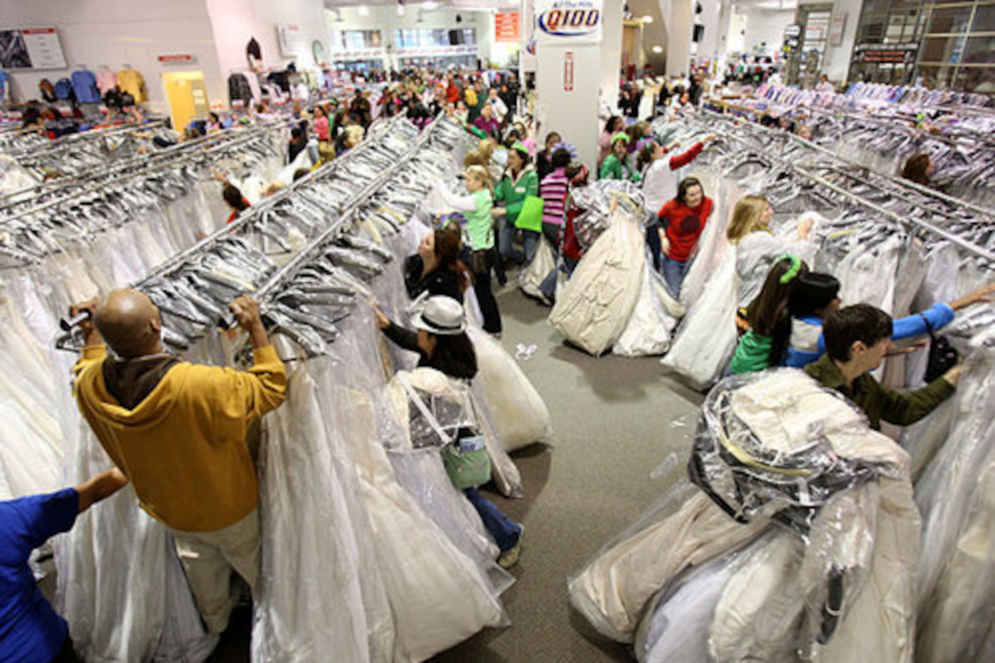 8:01 a.m.: The first brides and helpers get to the racks and grab handfuls of gowns.