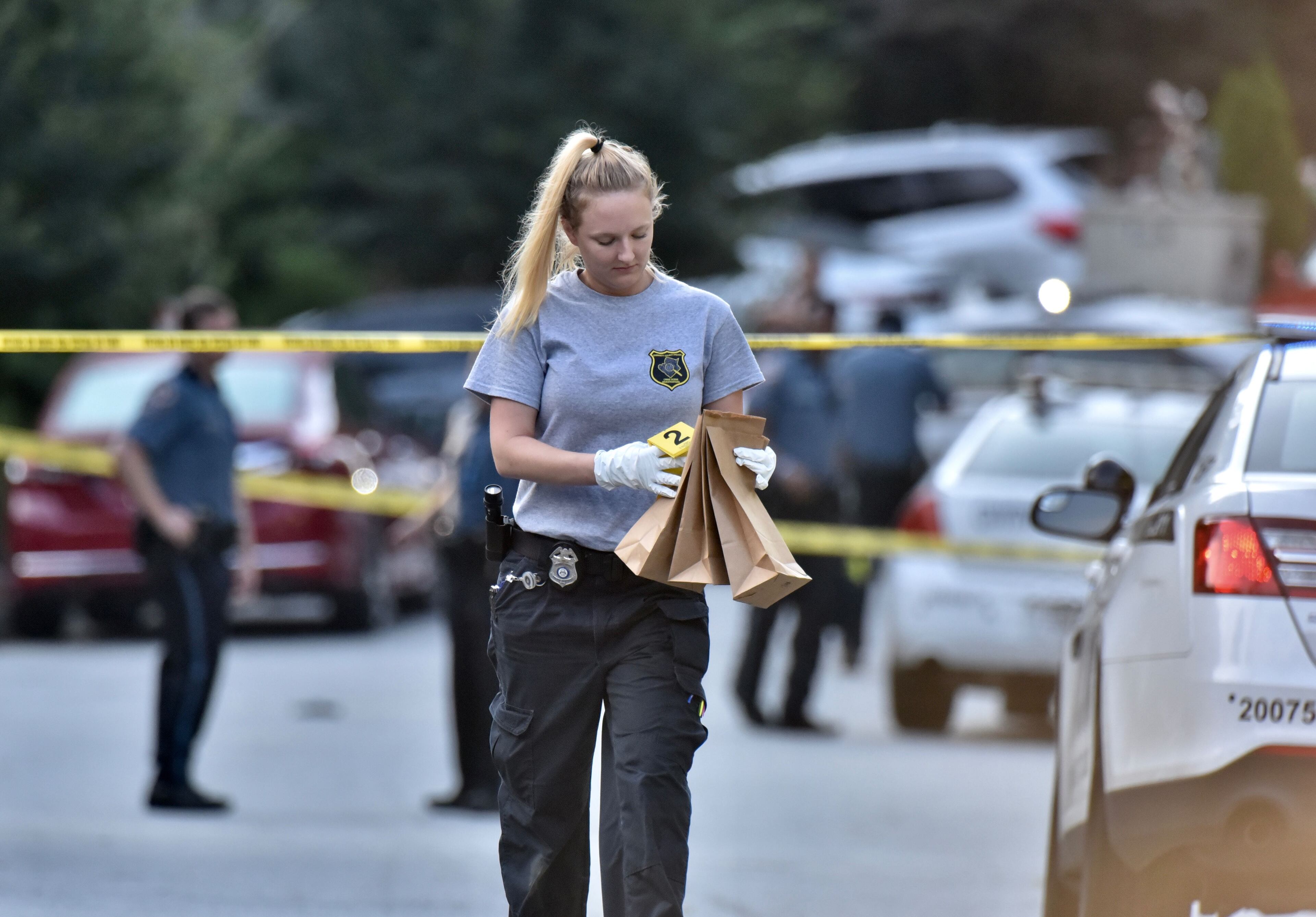 An investigator bags evidence at the scene Friday morning.