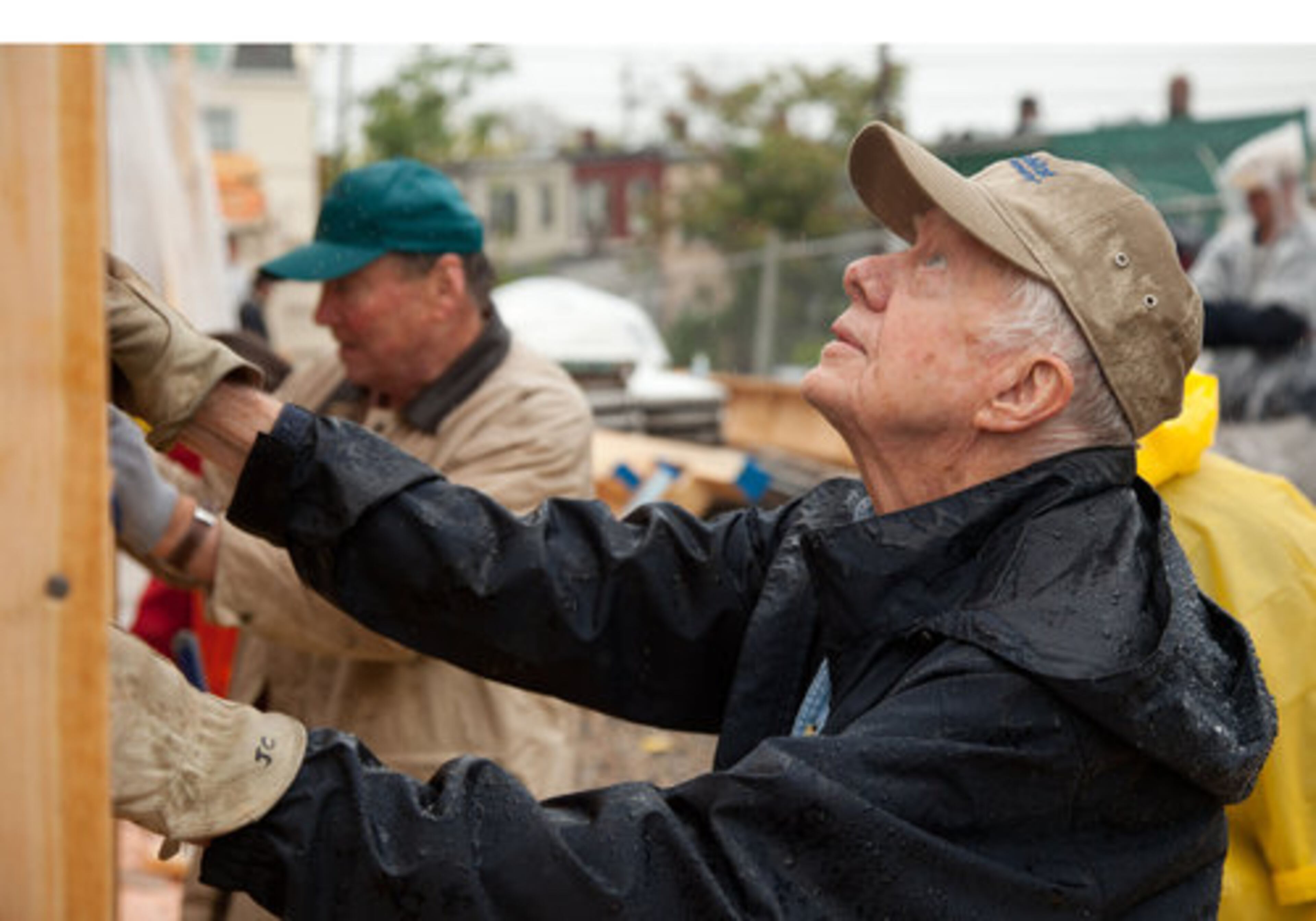 Former U.S. President Jimmy Carter works alongside other volunteers despite steady rainfall on the Ivy City, Washington, DC, build site of the 2010 Jimmy & Rosalynn Carter Work Project.