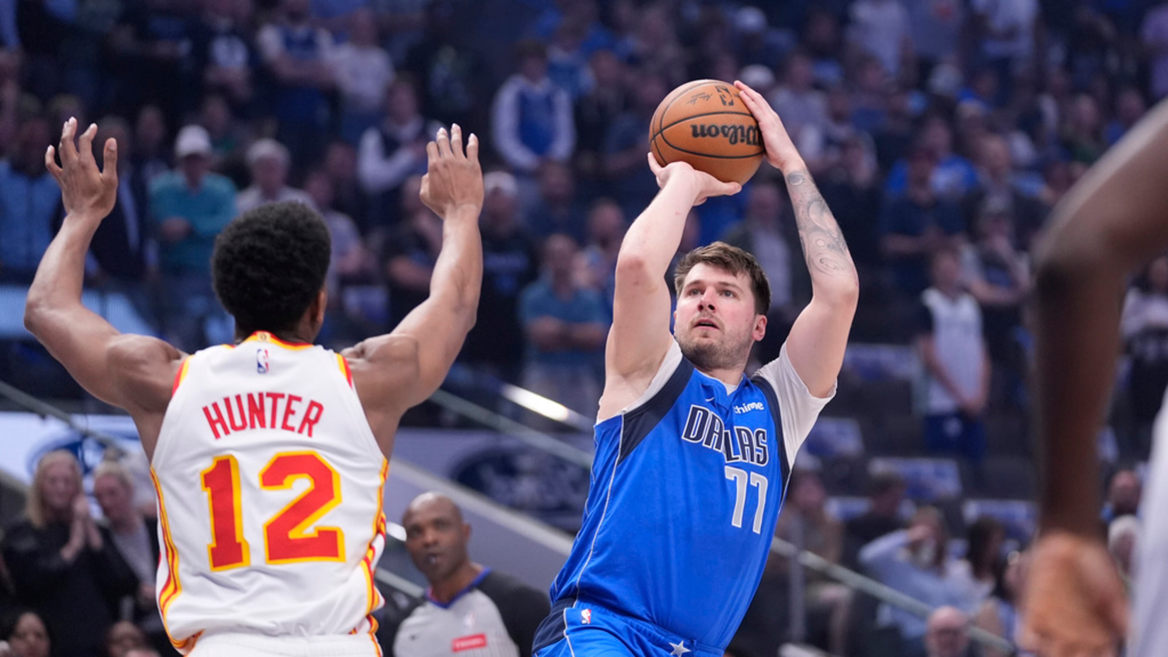 Dallas Mavericks guard Luka Doncic (77) shoots against Atlanta Hawks forward De'Andre Hunter (12) during the first half of an NBA basketball game in Dallas, Thursday, April 4, 2024. Dallas won 109-95. (AP Photo/LM Otero)