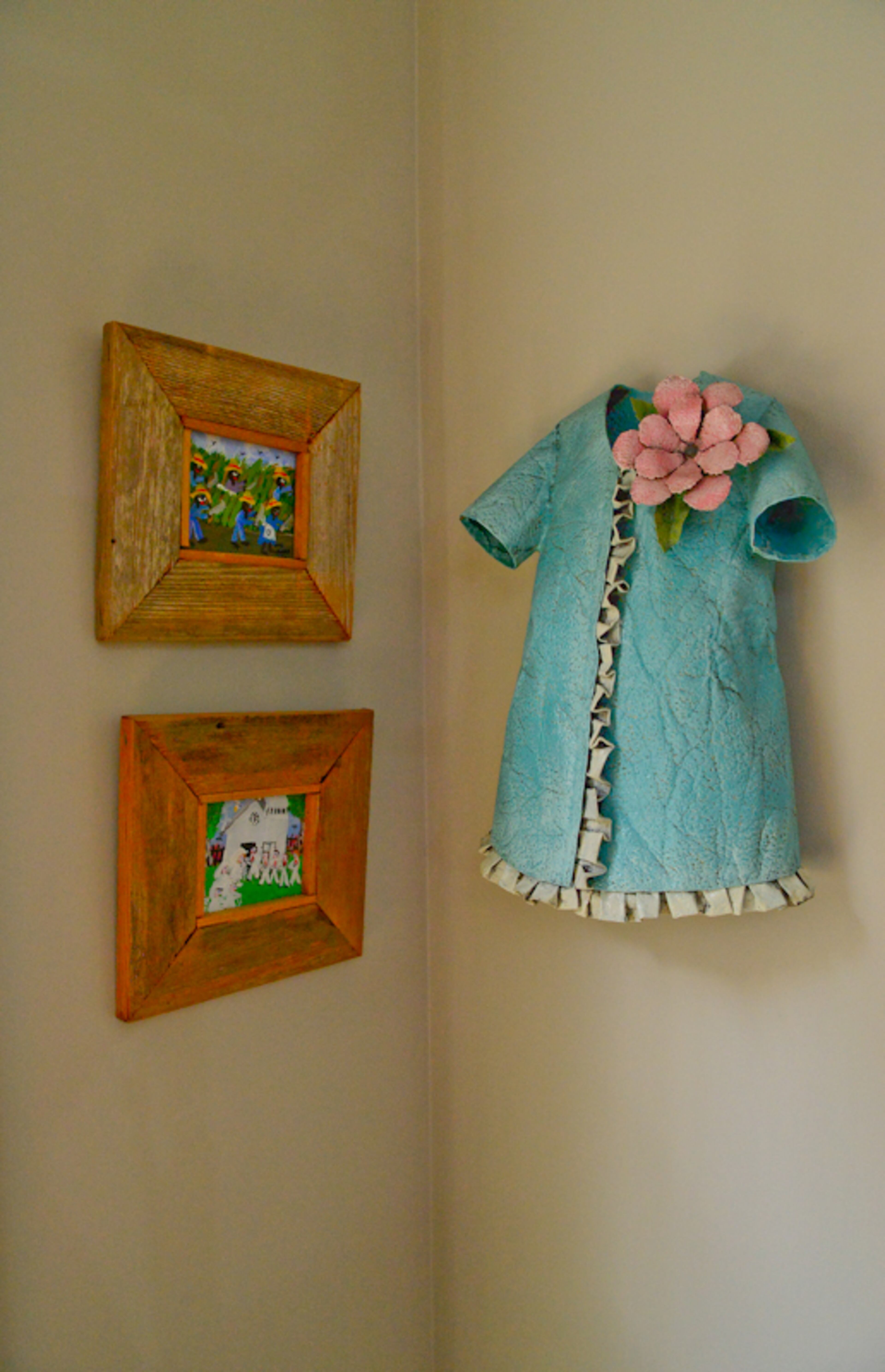 A sculpture in the form of a teal coat, by Chris Beck, and paintings by Shar Johns with rustic wood frames bring color, texture and folk art-style interest to a corner in the Atlanta townhome.