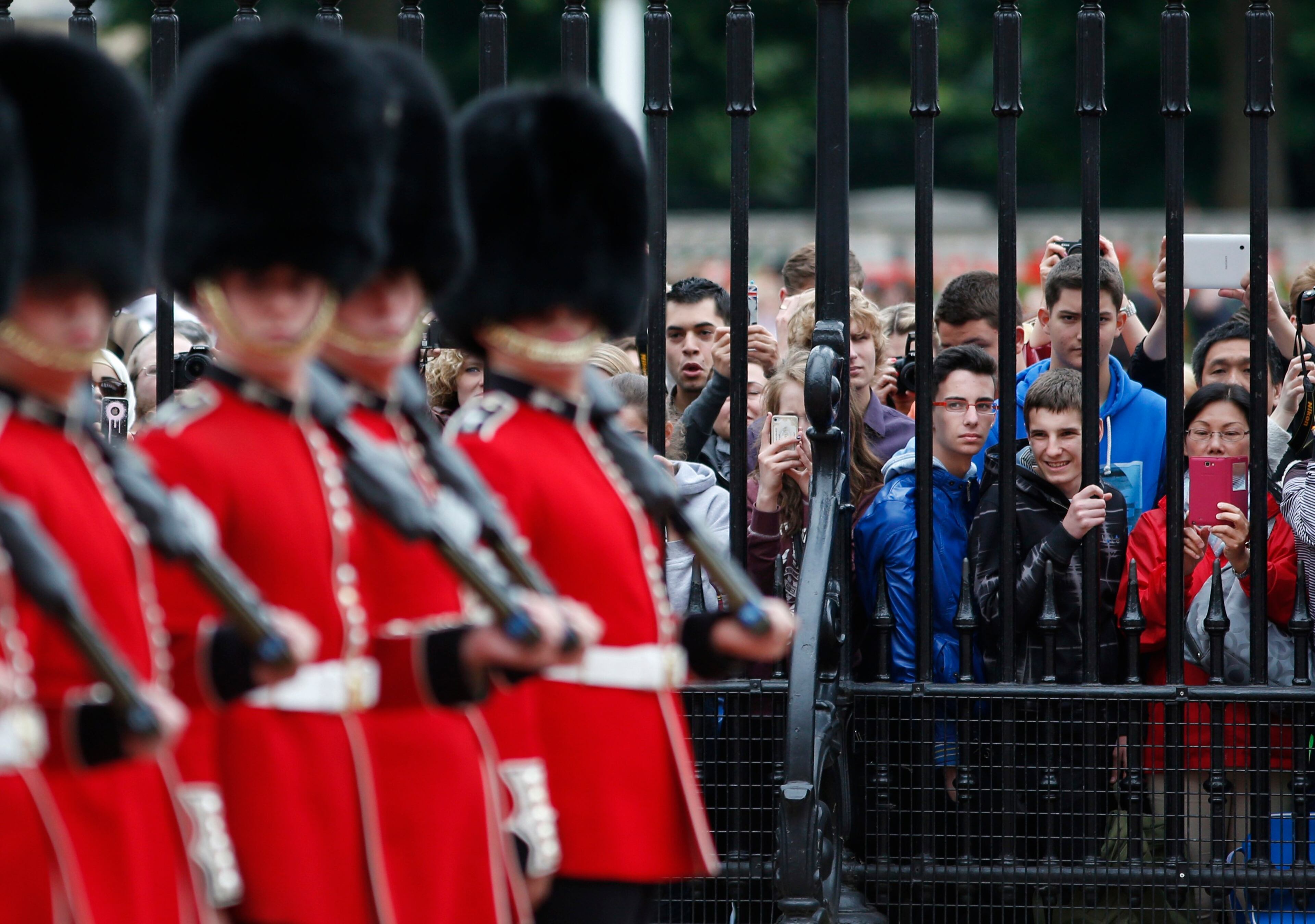 Members of the public watch as British soldiers, members of the House Guards participate at the Changing of the Guard ceremony, in the forecourt of Buckingham Palace in central London, Monday, June 16, 2014. Changing the Guard is one of the oldest and most familiar ceremonies associated with the Royal Palaces. In 1689, the court moved to St James's Palace, which was guarded by the Foot Guards. When Queen Victoria moved into Buckingham Palace in 1837, the Queen's Guard remained at St James's Palace, with a detachment guarding Buckingham Palace, as it still does today. (AP Photo/Lefteris Pitarakis)