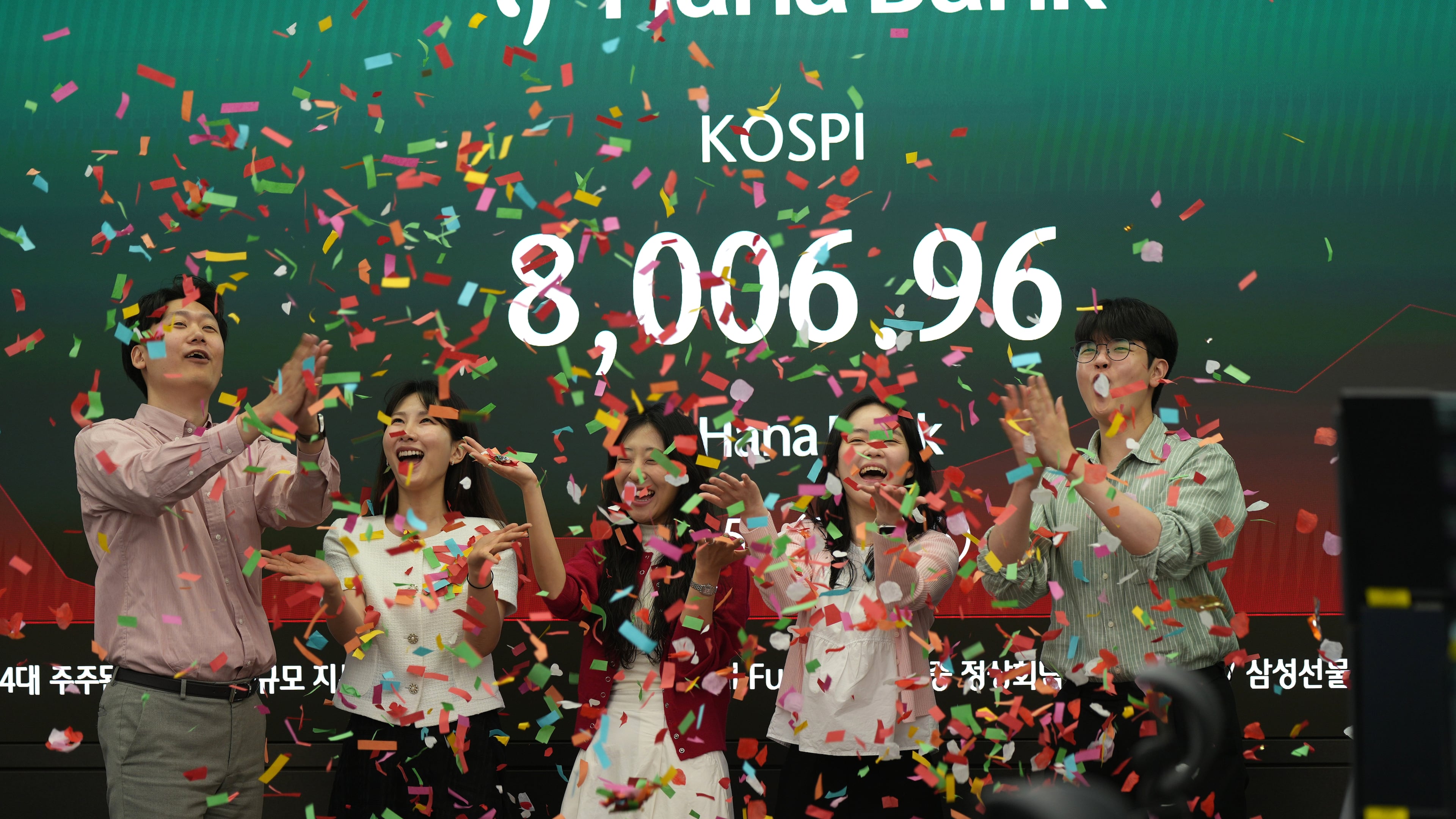 Employees of Hana Bank celebrate in a photo-op to mark the Korea Composite Stock Price Index (KOSPI) of over 8,000 points at a dealing room of Hana Bank in Seoul, South Korea, Friday, May 15, 2026. (AP Photo/Lee Jin-man)