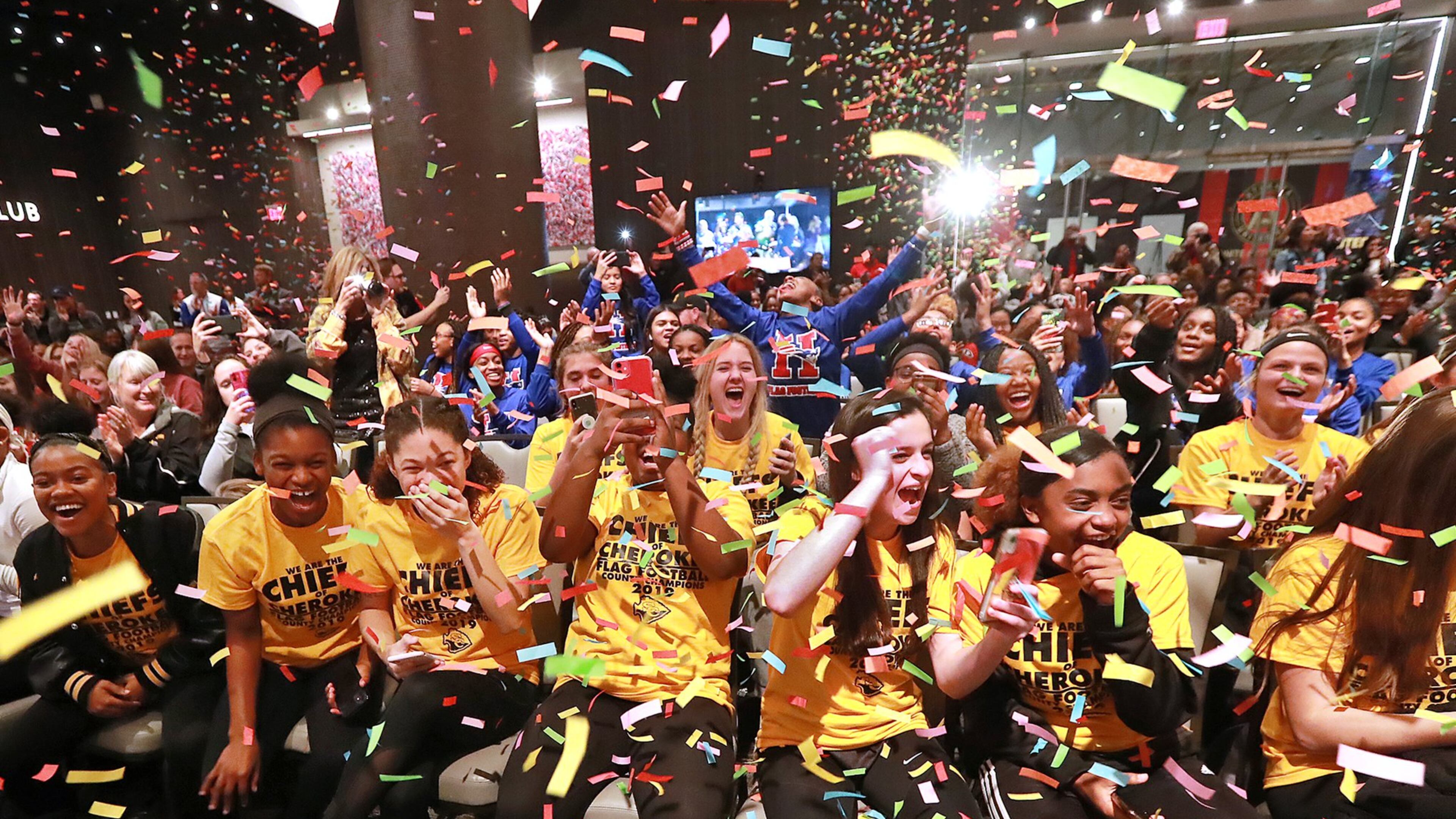 Confetti falls and the Chiefs of Cherokee (front) and five other girls football teams react as the Atlanta Falcons announce that in 2020 Georgia will become the fourth state to officially sanction girls high school flag football, during a rally before the Girls Flag Football Championship at Mercedes-Benz Stadium on Wednesday, Dec. 18, 2019, in Atlanta. CURTIS COMPTON/CCOMPTON@AJC.COM