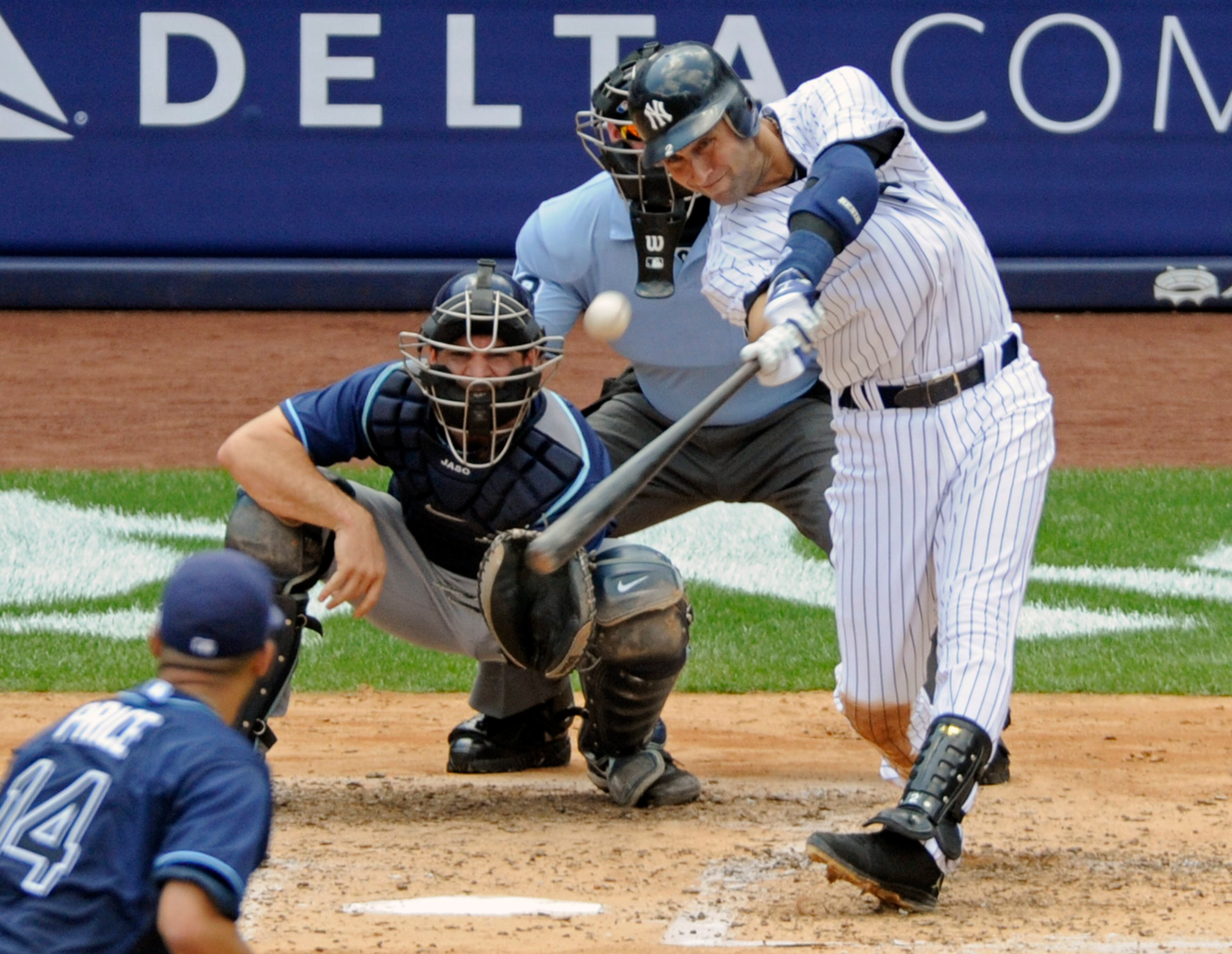 FILE - In this July 9, 2011, file photo, New York Yankees' Derek Jeter hits a home run for his 3,000th career hit during the third inning of a baseball game against the Tampa Bay Rays at Yankee Stadium in New York. Rays catcher John Jaso, pitcher David Price, left, and umpire Jim Wolf look on. Jeter became the 28th major leaguer to hit the milestone and also the first Yankees player. (AP Photo/Bill Kostroun, File)