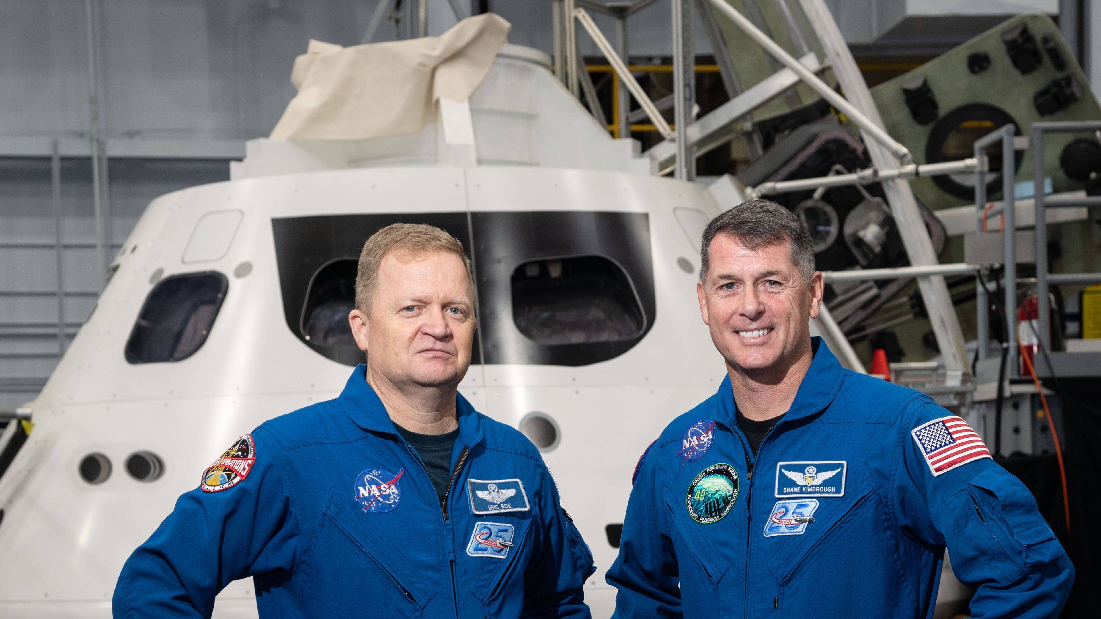 Astronauts Eric Boe (left) and Robert Shane Kimbrough stand with a mock-up of the Orion spacecraft at NASA s Johnson Space Center in Houston.