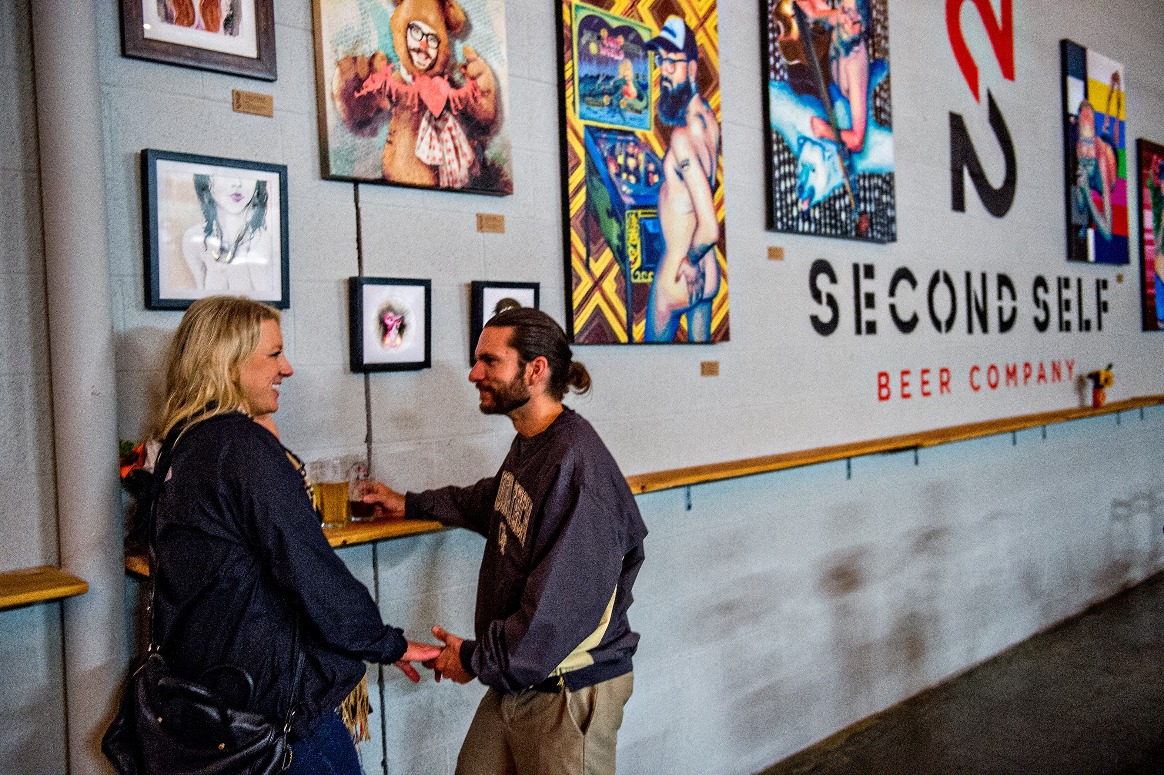 October 3, 2015 Atlanta - Kimberly Tokars (left) holds hands with Kenny Mills during the Second Self Beer Company's one year anniversary celebration in Atlanta on Saturday, October 3, 2015. The brewery had 16 different beers to sample during the celebration. JONATHAN PHILLIPS / SPECIAL
