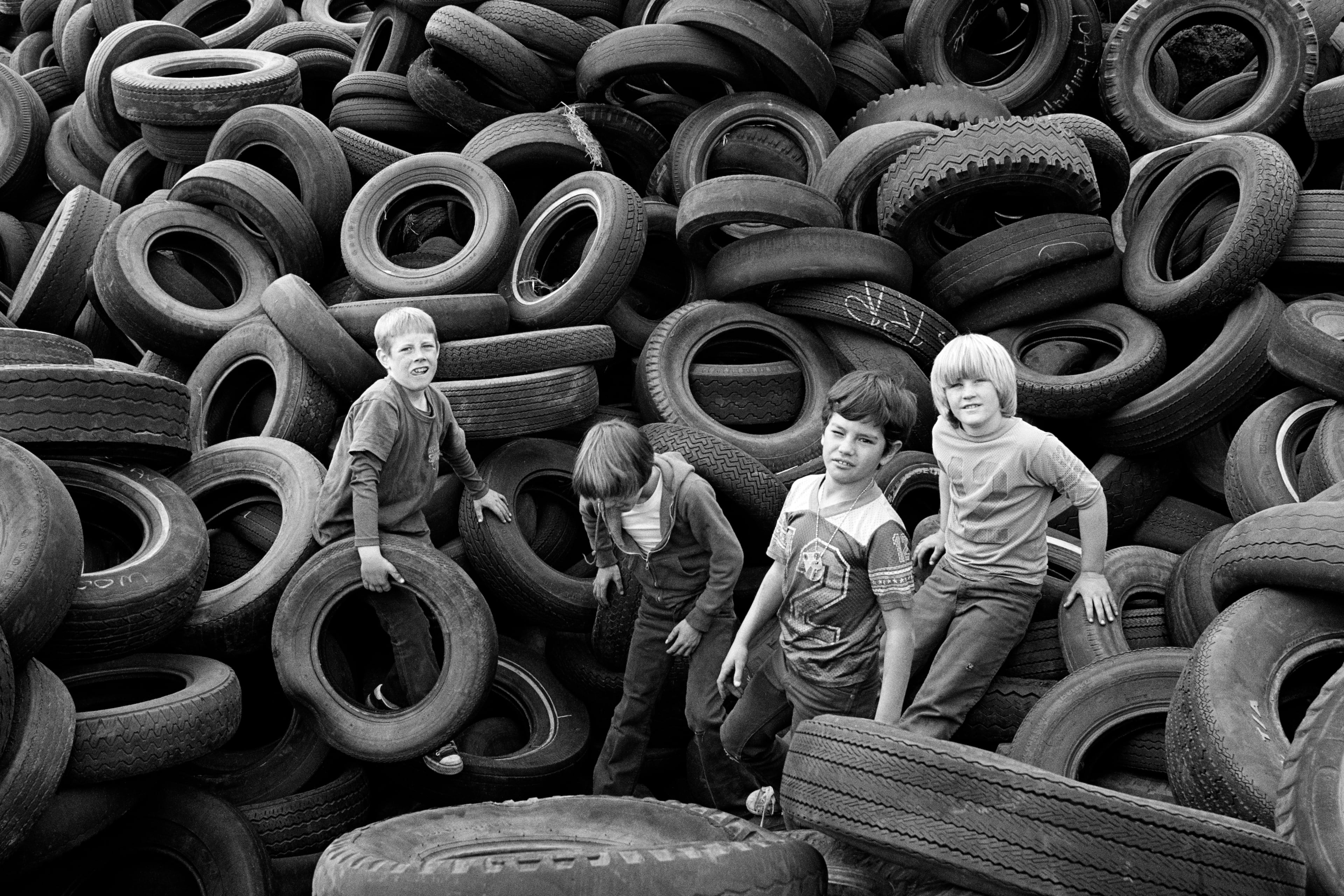 "Boys and Tires, Sears Point" (1976) by Mimi Plumb. Photos in this section of the "Blazing Light" exhibit "have this sense of the waning optimism of the 1960s,” says curator Gregory J. Harris. (Photo courtesy of the High Museum of Art/© Mimi Plumb)