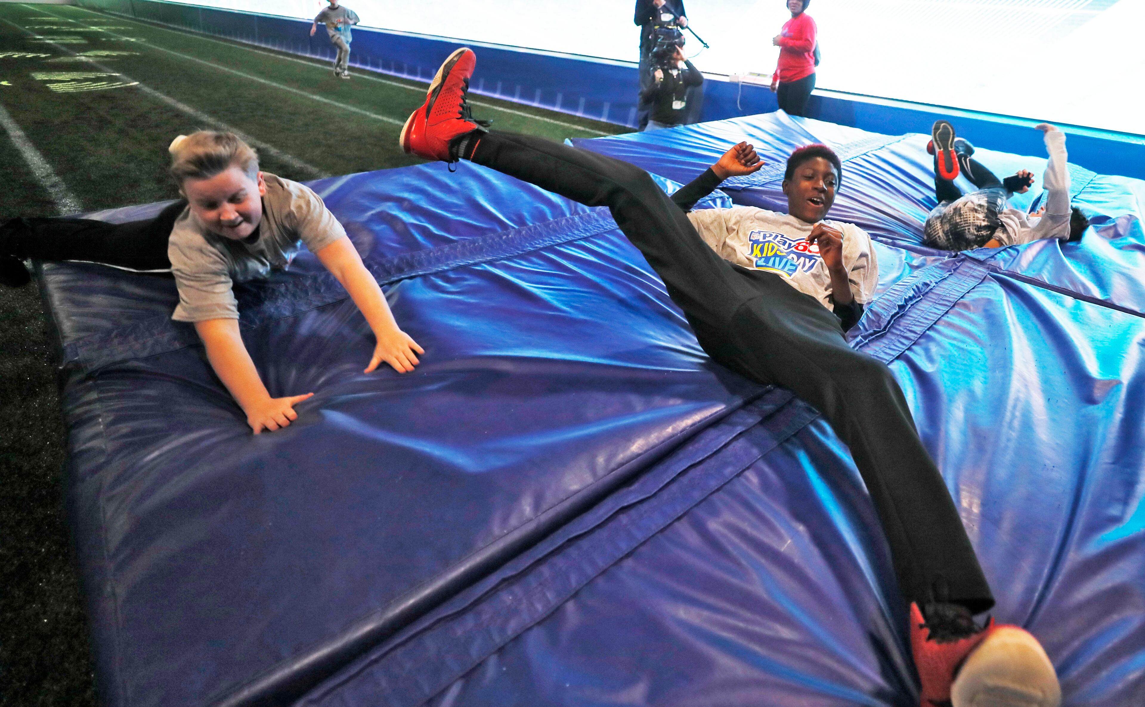 1/30/19 - Atlanta - Students from Marbut Ellementary School in Lithonia crash land at the end of the 40 yard dash attraction. NFL PLAY 60 Kids' Day gave more than 2,000 local youth to spend the day at the Super Bowl Experience. The kids were free to roam through the many attractions at the Georgia World Congress Center. Bob Andres / bandres@ajc.com