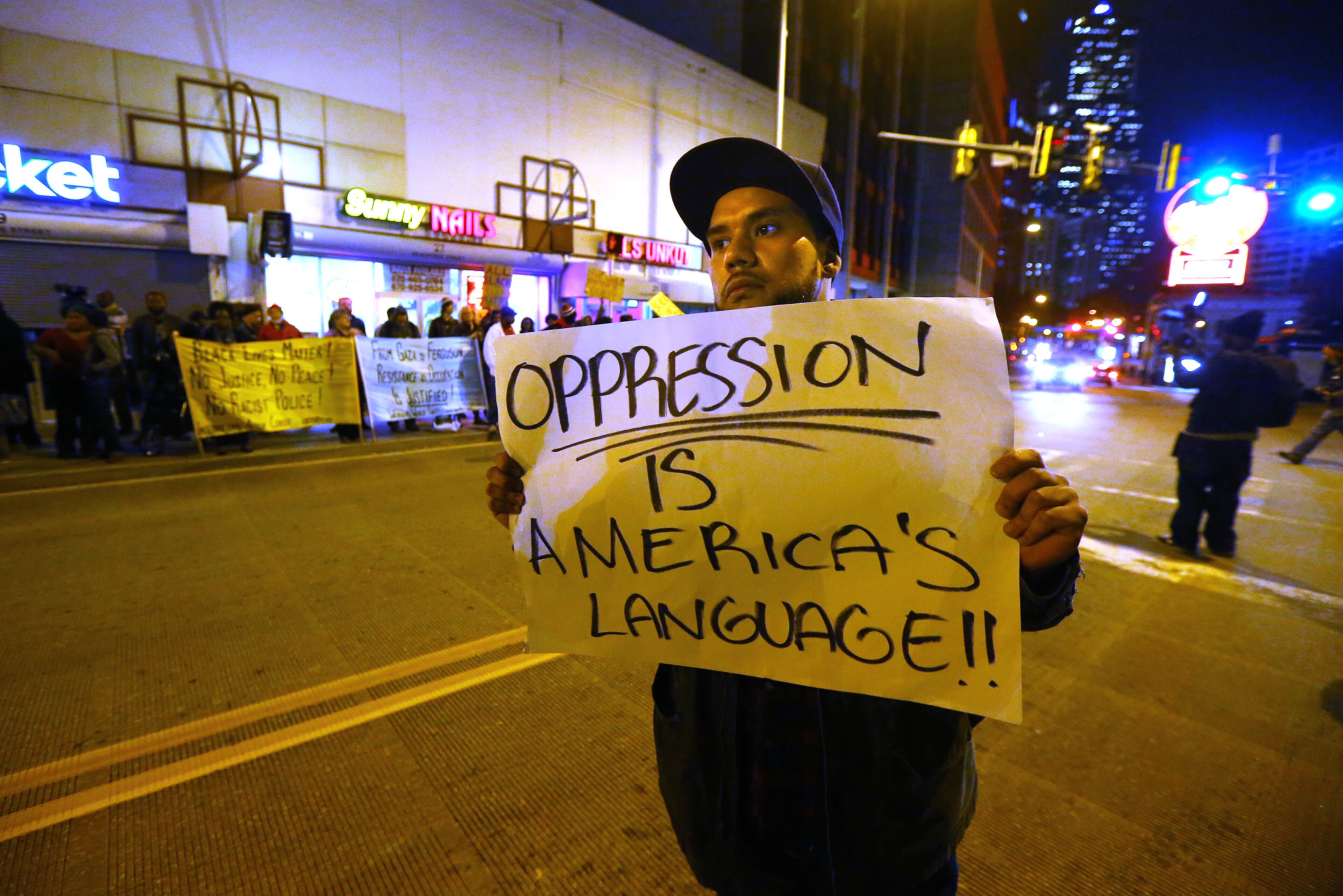 Jamel Rivera, Sandy Springs, walks down Peachtree Street joining in a protest at Underground Atlanta in the wake of the grand jury decision not to indict officer Darren Wilson in the shooting death of Ferguson, MO., teen Michael Brown. CURTIS COMPTON / CCOMPTON@AJC.COM