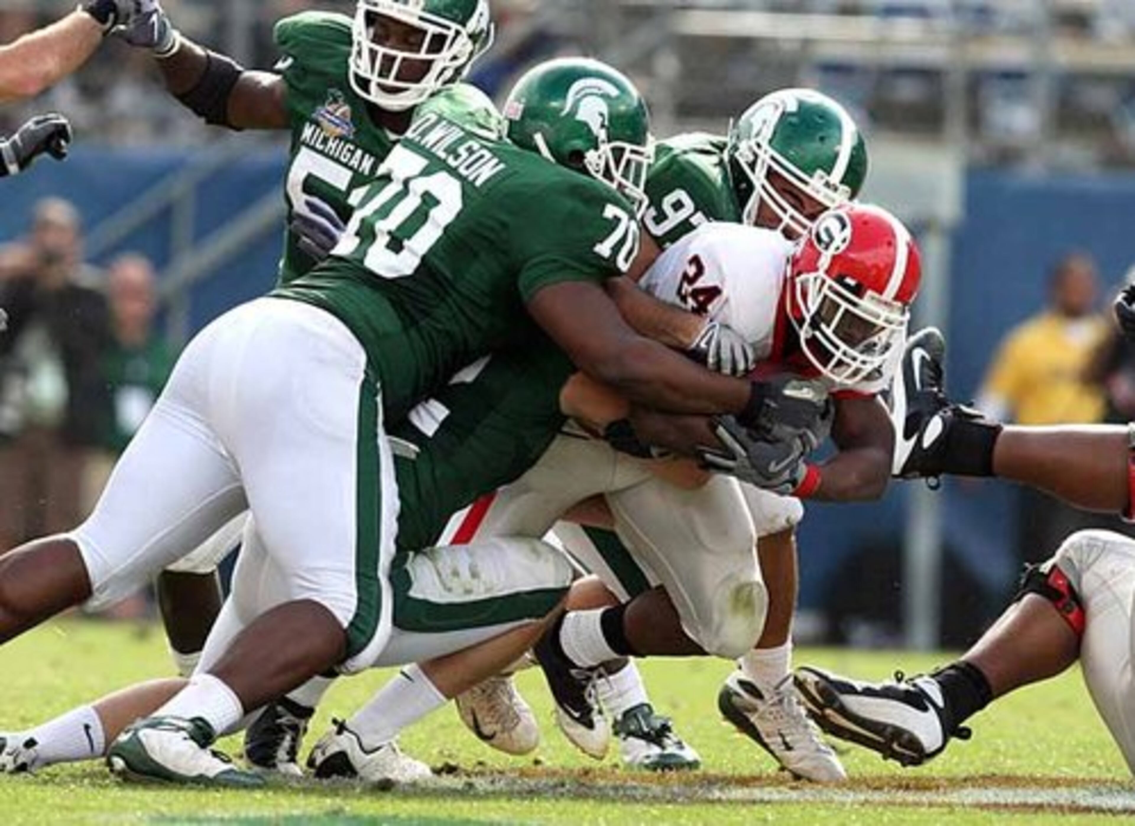 Georgia RB Knowshon Moreno (24) is hit by a group of Michigan State defenders during first half action.