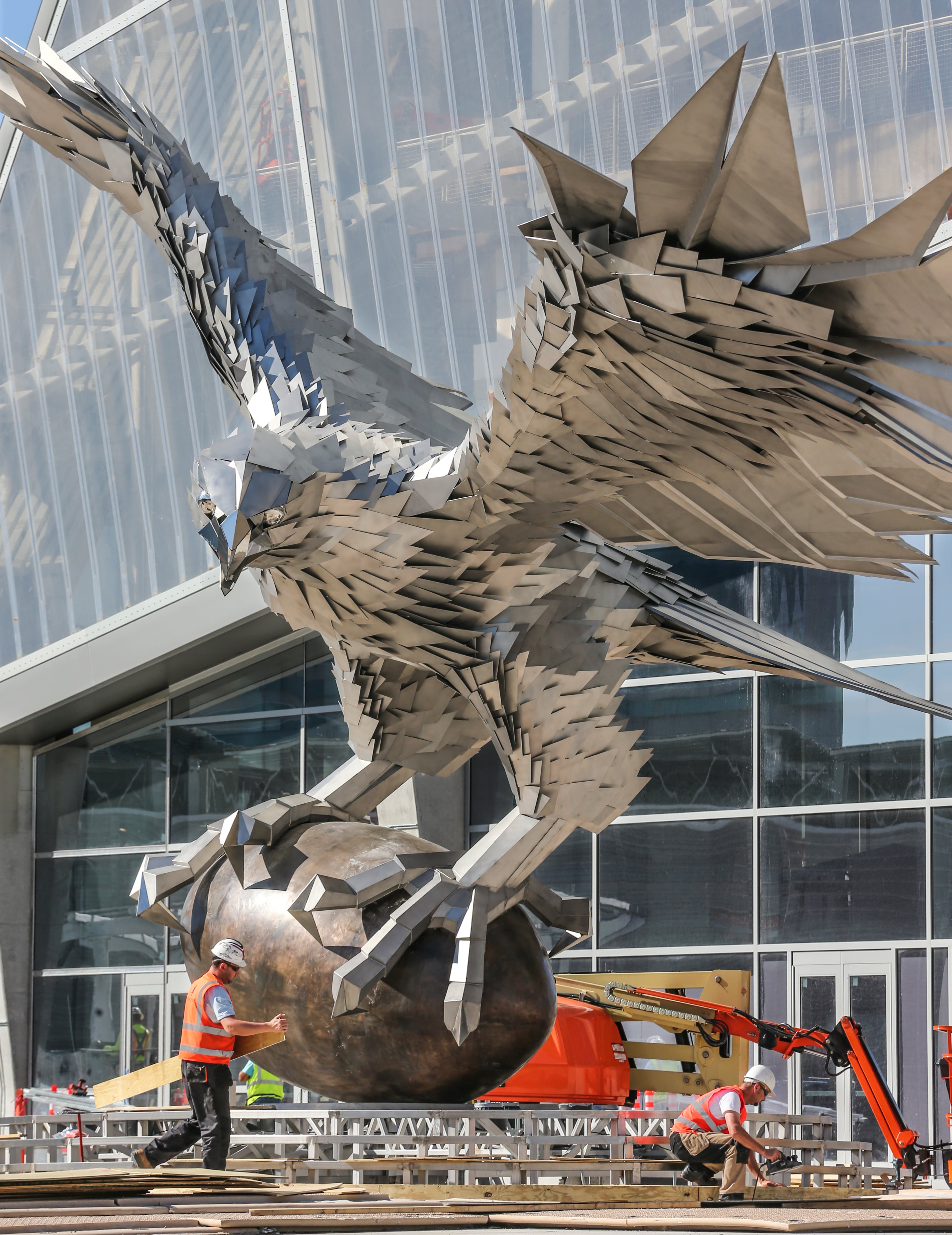 May 3, 2017 Atlanta: Workers continued construction around the base of a 41.5-foot tall statue of a falcon, hailed as the largest bird sculpture in the world on Wednesday, May 3, 2017 after it was set into place at Mercedes-Benz Stadium and erected on the main plaza facing the city skyline. The giant bird with a wingspan of more than 64 feet -- was installed last week. The stainless steel statue constructed by Hungarian artist Gabor Miklos Szoke captures the moment of a touchdown. The Falcons will open Mercedes-Benz Stadium with an exhibition game Aug. 26 against the Arizona Cardinals. JOHN SPINK/JSPINK@AJC.COM