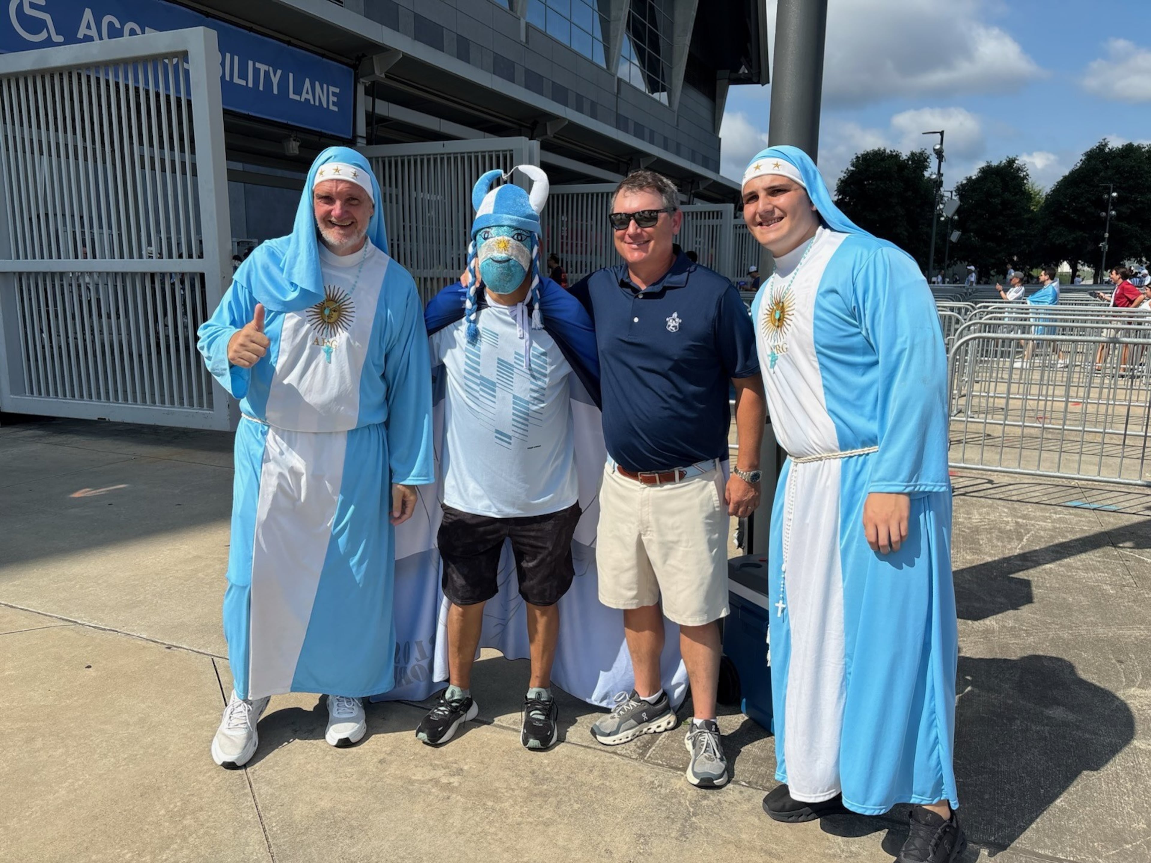 The two gents on the far left and right were a popular photo request from fans before Tuesday's Argentina-Egypt game at "Atlanta Stadium." They apparently have achieved a degree of fame for being Argentina's "nun fans." The one making the thumbs-up sign looks a little bit like an older Will Forte, the former Saturday Night Live cast member. (AJC photo by Ken Sugiura)