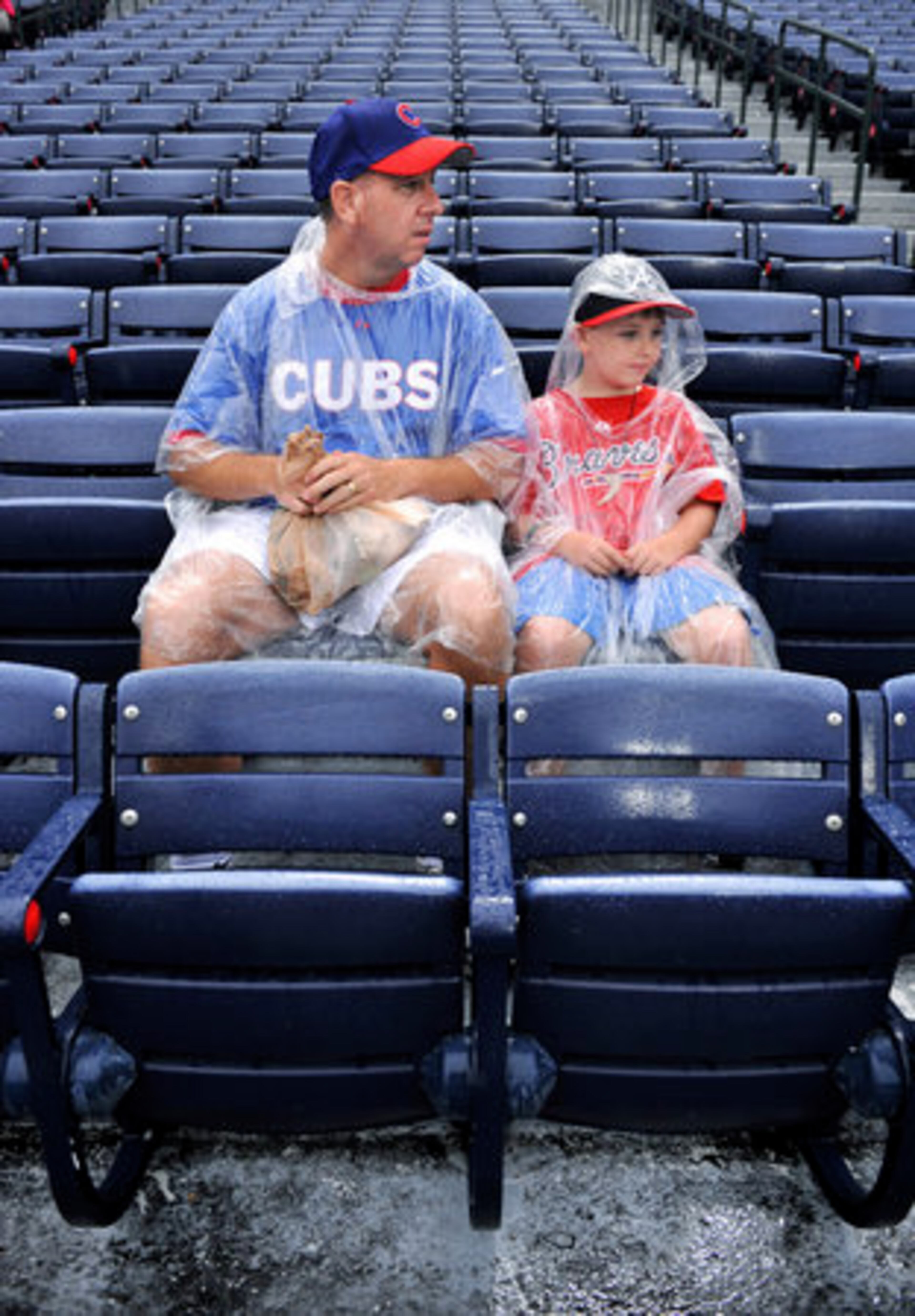 Cubs fan Jeff Esping and his son, Ryan, 8, wait for the game to start. Esping brought his son to witness the Cubs play, but young Ryan, a Braves faithful, says he has no interest in the Cubs.