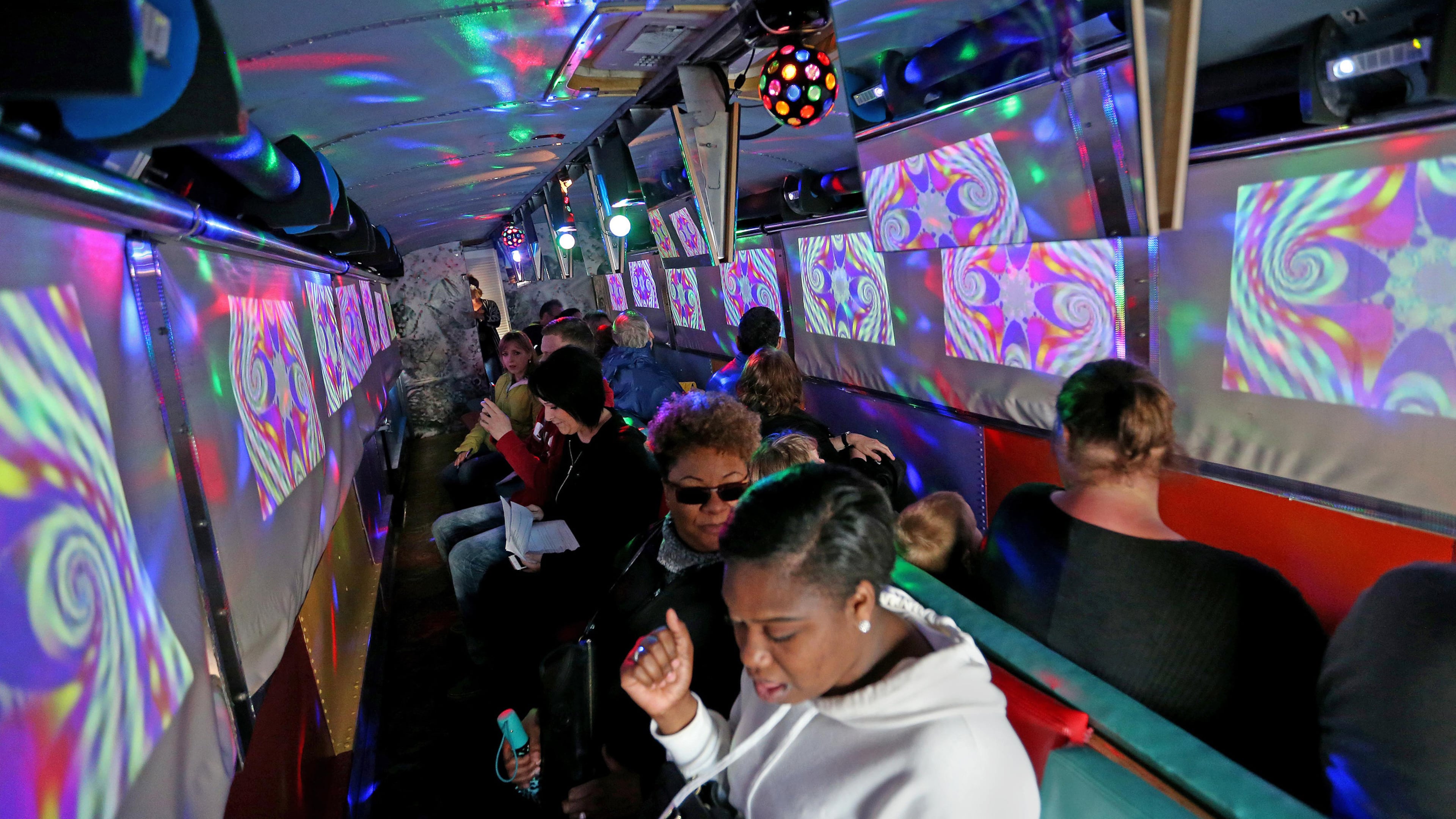 People ride the psychedelic Magic Bus tour in San Francisco, Calif., on Saturday, April 8, 2017. The two-hour tour takes people through Haight Ashbury, North Beach, Golden Gate Park and other parts of the city in a vintage bus as historic videos and music of the era play. This year marks the 50th anniversary of the Summer of Love in 1967. (Jane Tyska/Bay Area News Group/TNS)