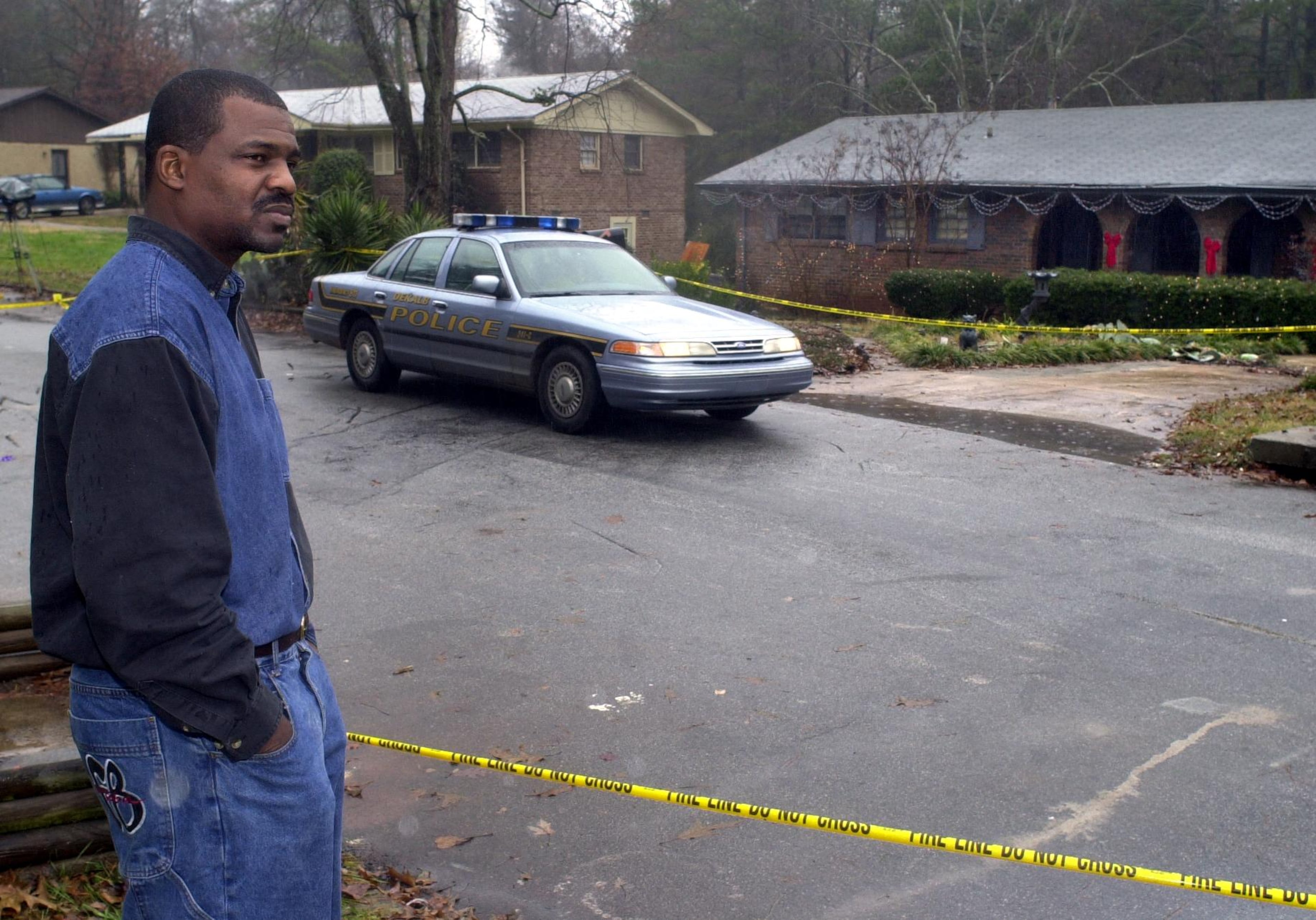 Randy Ogletree, a friend of DeKalb County Sheriff-elect Derwin Brown, looks sadly over the scene where Brown was gunned down. Brown's home is in the background on the right, with red bows. (Cathy Seith / AJC File)