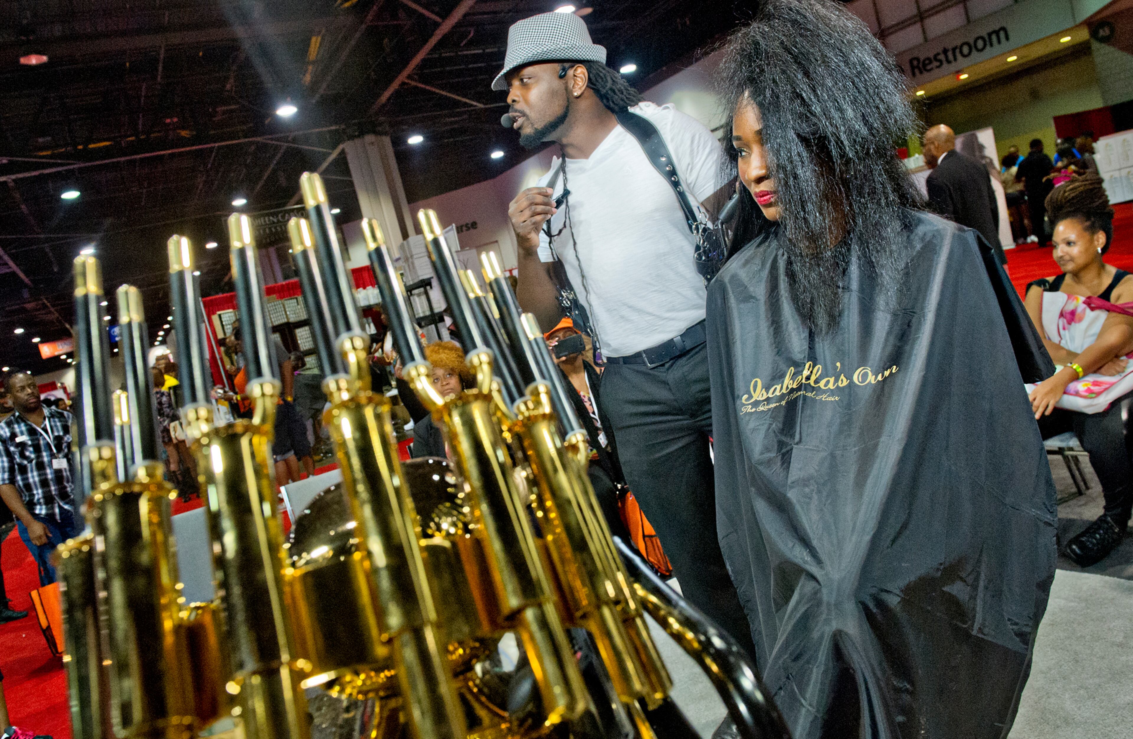 Marvin Hayes (center) talks to the crowd as he works on Tomecia Bradley's hair during the Bronner Bros. International Hair Show at the Georgia World Congress Center in Atlanta on Saturday, August 2, 2014. The four day, 67th annual show consisted of competitions and demonstrations for hair, makeup and nails. JONATHAN PHILLIPS / SPECIAL
