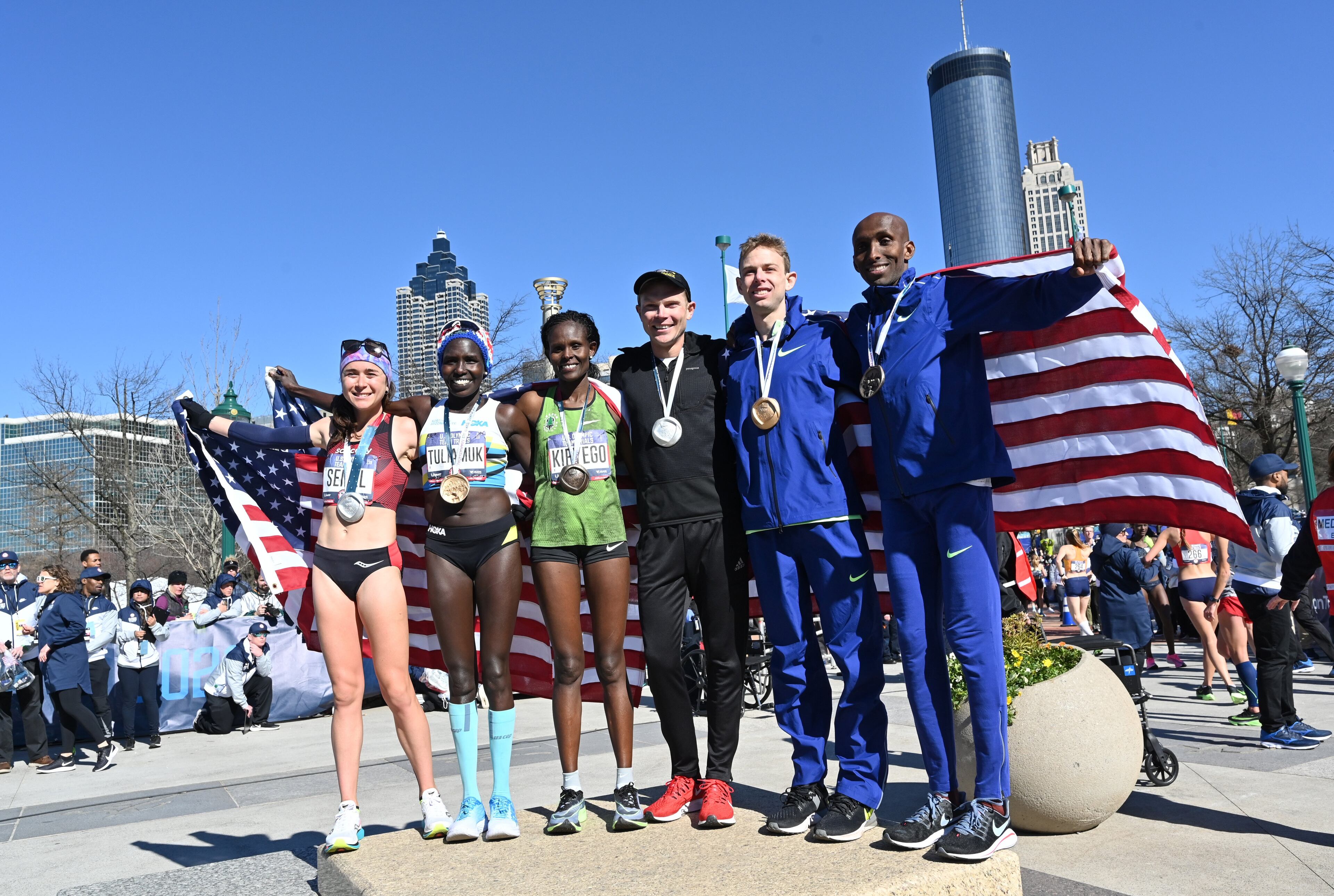 The first six American athletes heading to the Olympic Games in Tokyo, (from left) Molly Seidel, Aliphine Tuliamuk, Sally Kipyego, Jacob Riley, Galen Rupp and Abdi Abdirahman, pose for a photo after they finished the 2020 U.S. Olympic Team Trials Marathon in downtown Atlanta on Saturday, February 29, 2020. (Hyosub Shin / Hyosub.Shin@ajc.com)