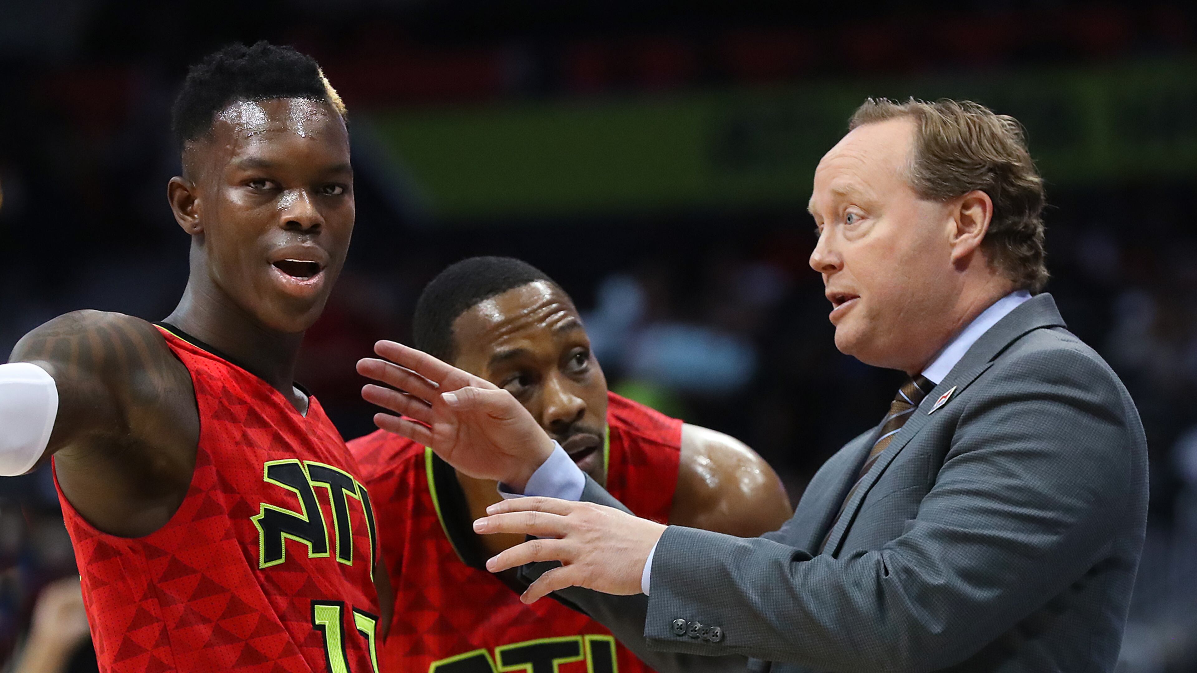 Hawks coach Mike Budenholzer confers with guard Dennis Schroder and center Dwight Howard during Sunday's loss to the Brooklyn Nets. (Curtis Compton/ccompton@ajc.com)