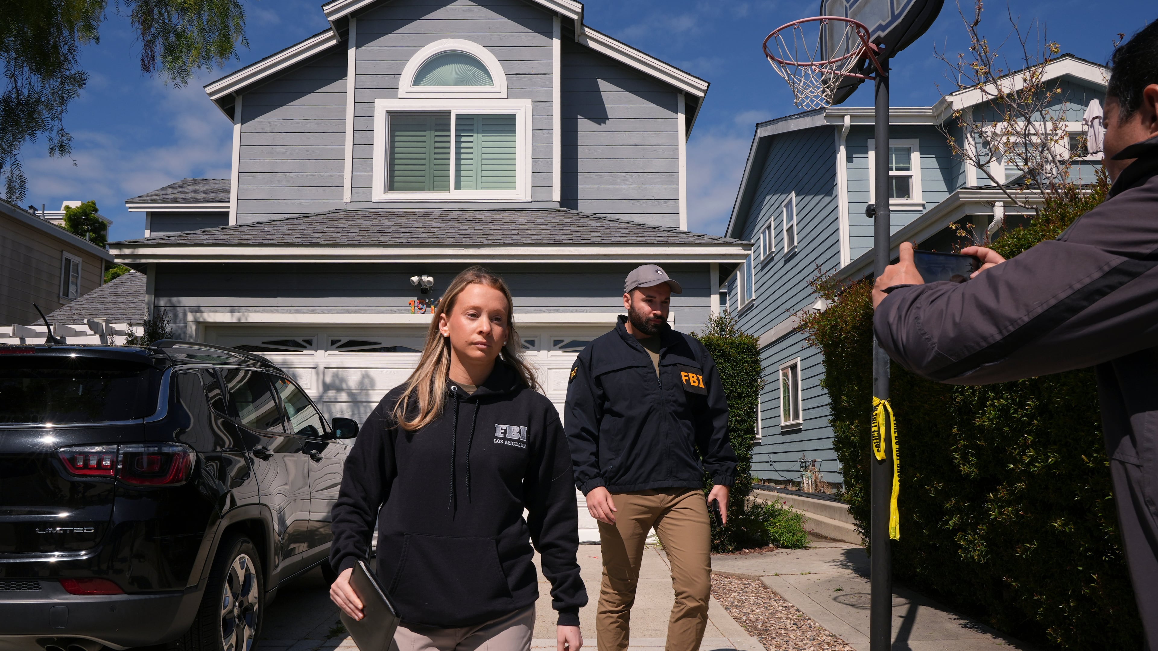 FBI agents walk door to door to try to speak with neighbors as members of the media follow them, Sunday, April 26, 2026, near an address in Torrance, Calif., connected to Cole Tomas Allen, who was identified as the shooting suspect at the White House Correspondents Dinner the night before. (AP Photo/Damian Dovarganes)