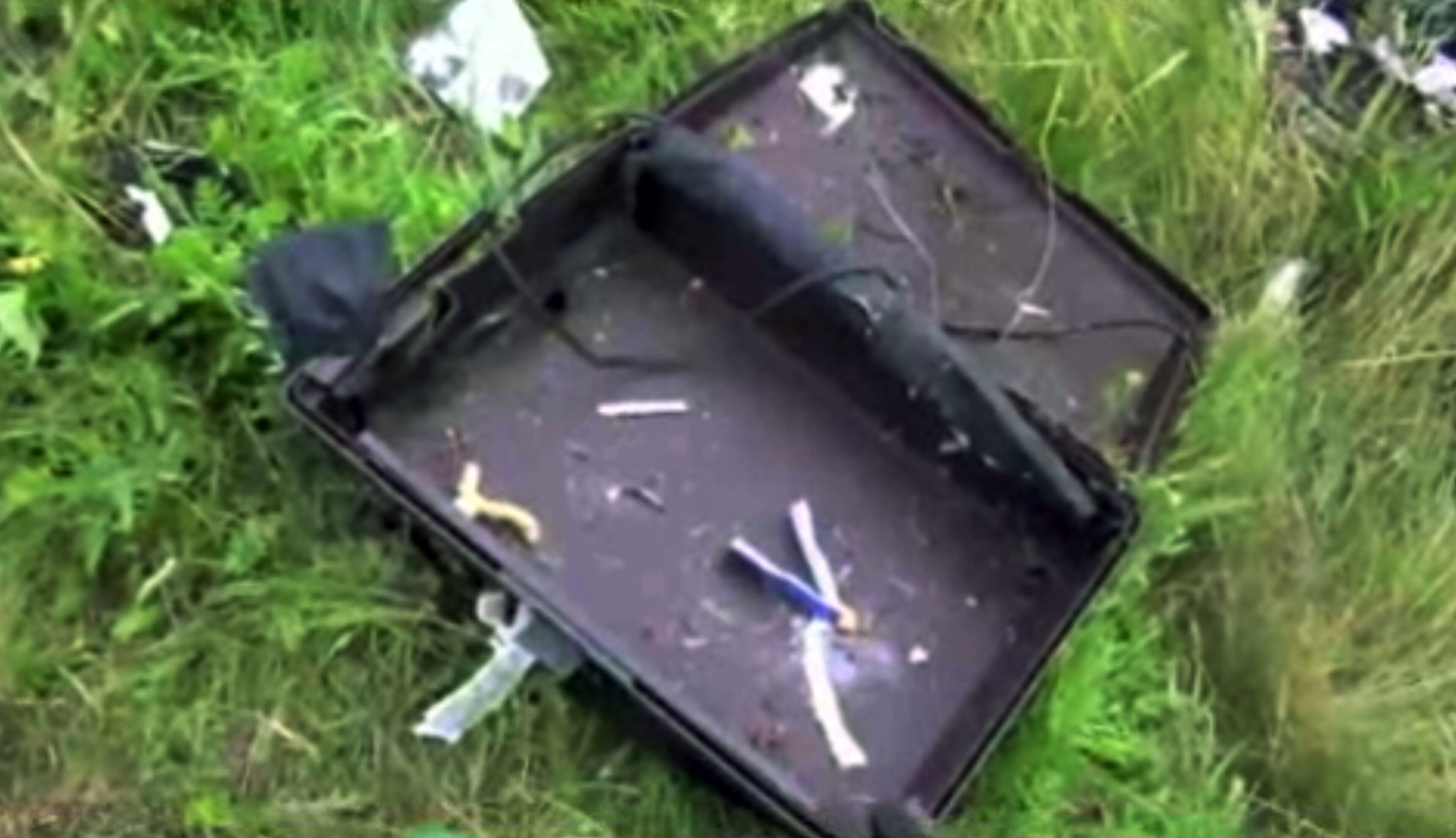 This image taken from video, Thursday July 17, 2014, shows a suitcase found in the wreckage of a passenger plane carrying 295 people after it was shot down Thursday as it flew over Ukraine, near the village of Hrabove, in eastern Ukraine. Malaysia Airlines tweeted that it lost contact with one of its flights as it was traveling from Amsterdam to Kuala Lumpur over Ukrainian airspace. (AP Photo/Channel 1)