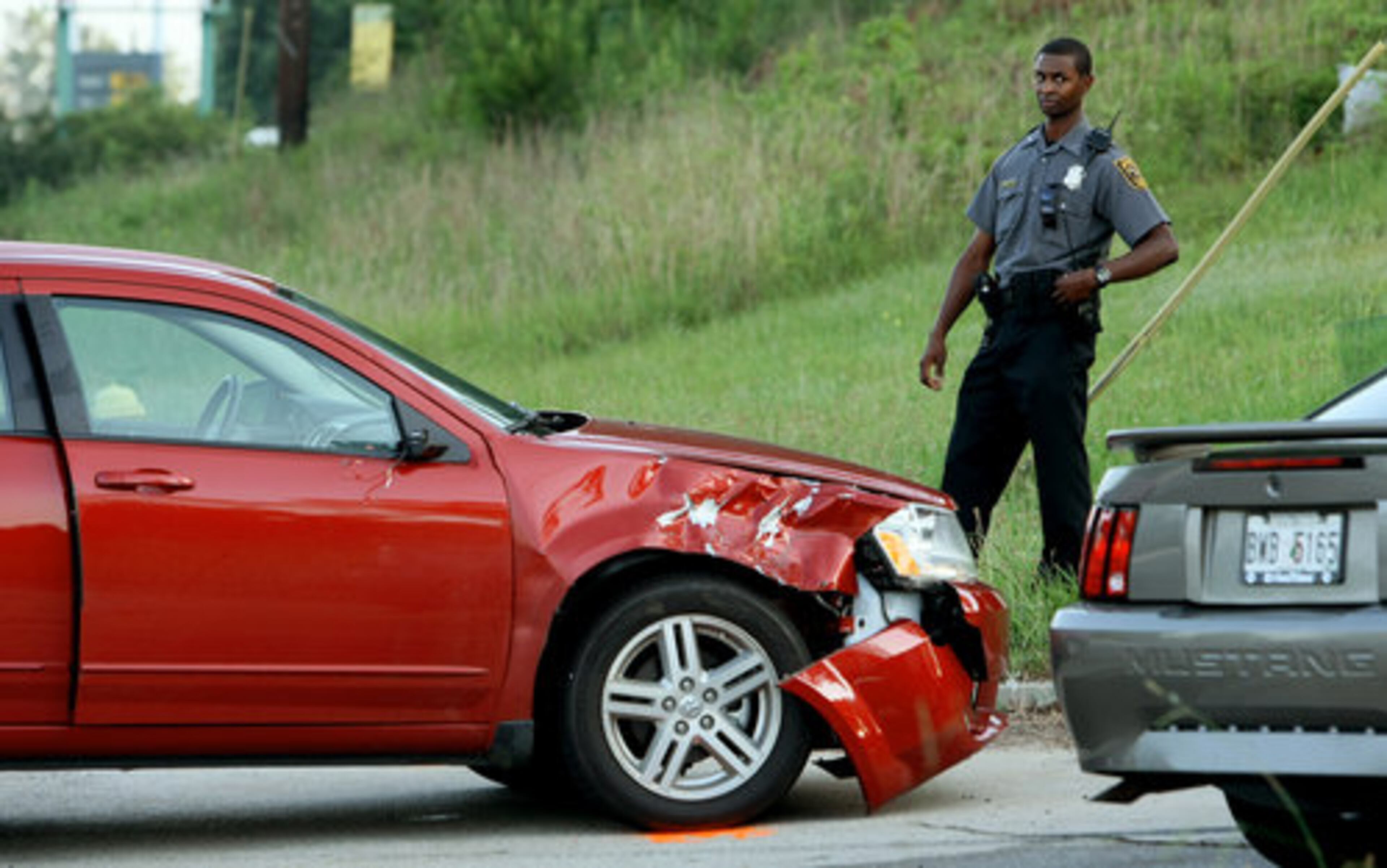 A DeKalb police officer stands by one of two cars being investigated Friday morning.