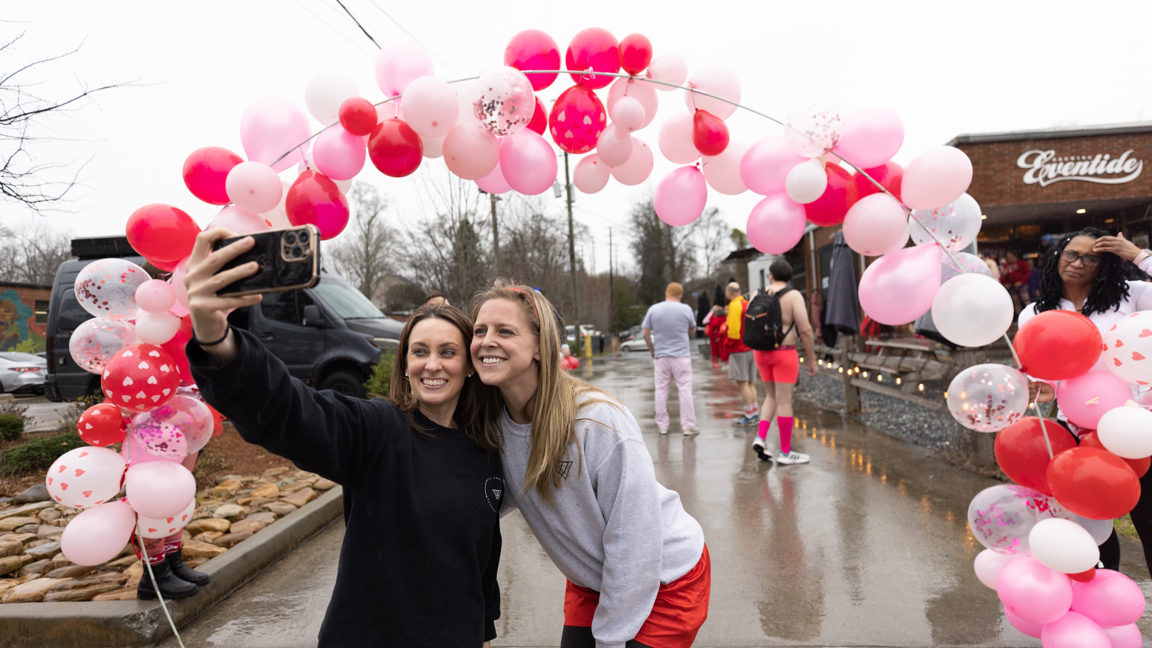 Volunteers Renee Doddinaton (left) and Elizabeth Rudd take a selfie in front of the starting line before the start of the Cupid's Undie Run Atlanta 2023 at Eventide Brewing near Grant Park on Saturday, Feb. 11, 2023. The annual event raises funds to support people affected by the genetic disorder neurofibromatosis. (Photo: Steve Schaefer / steve.schaefer@ajc.com)