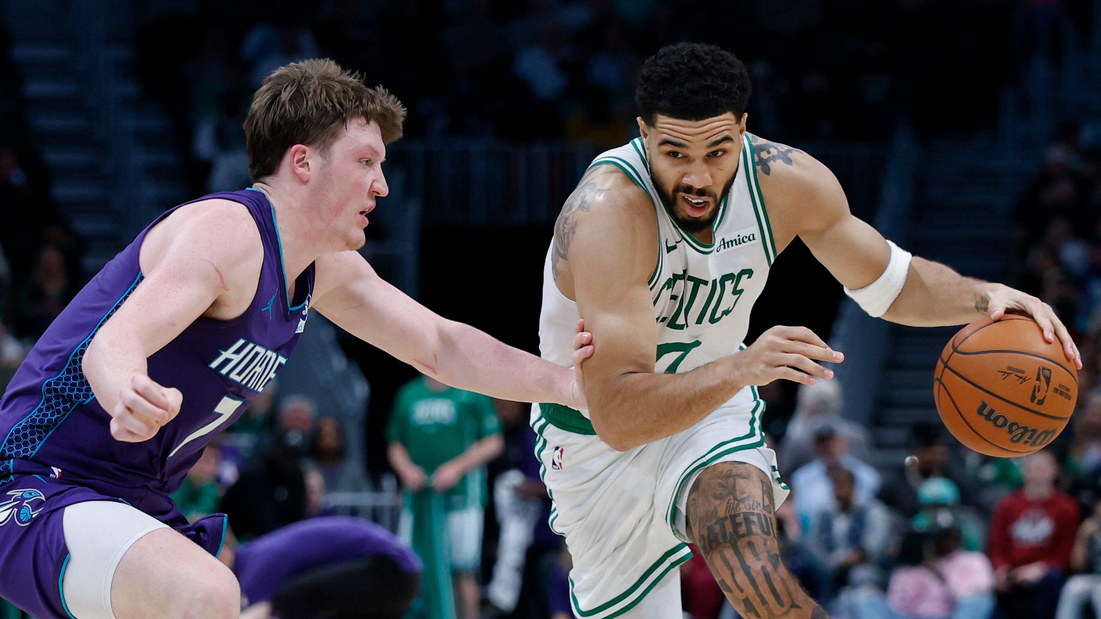 Boston Celtics forward Jayson Tatum, right, drives against Charlotte Hornets guard Kon Knueppel during the second half of an NBA basketball game in Charlotte, N.C., Sunday, March 29, 2026. (AP Photo/Nell Redmond)