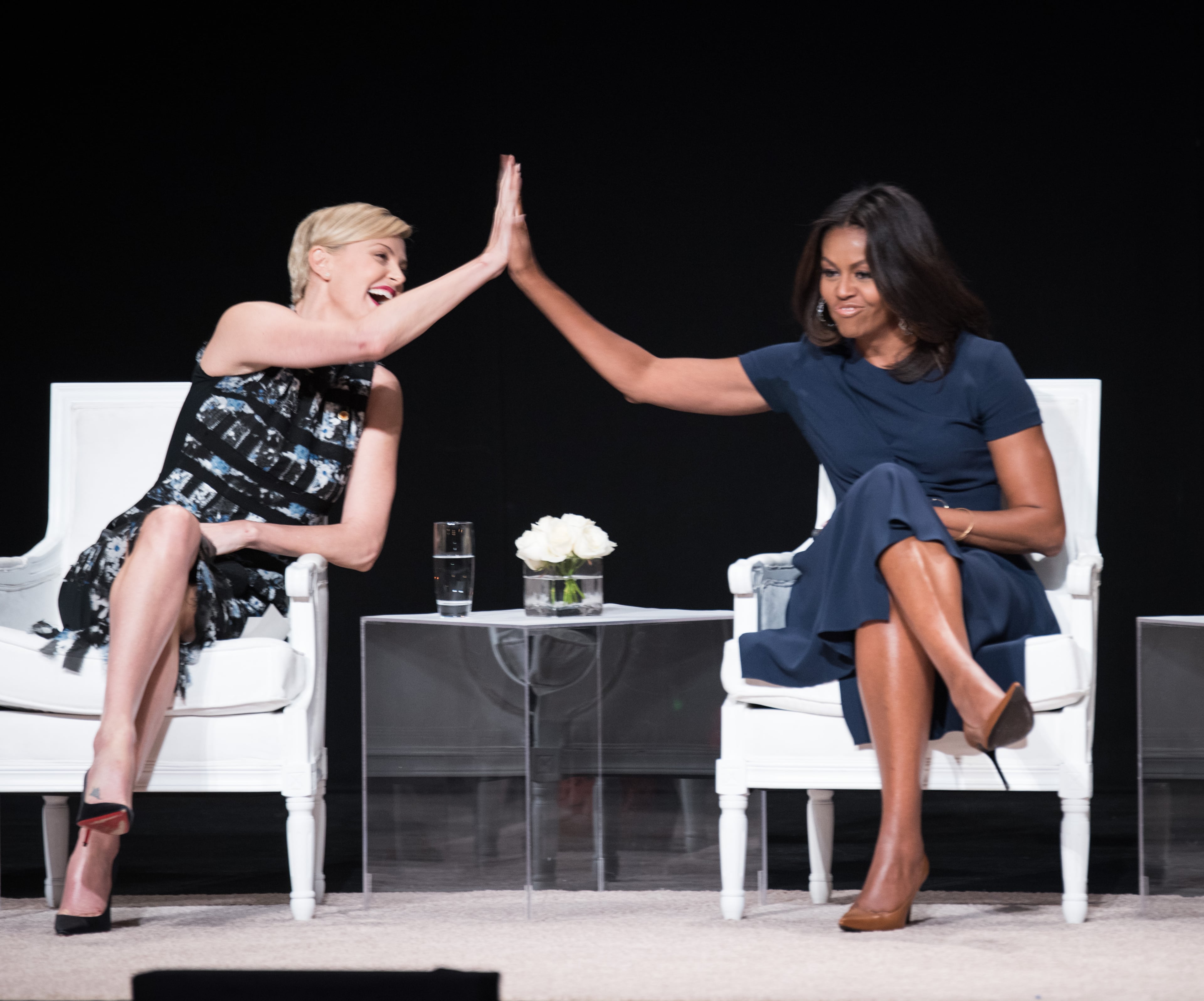 NEW YORK, NY - SEPTEMBER 29: Founder of Charlize Theron Africa Outreach Project and U.N. Messenger of Peace Charlize Theron (L) and First Lady of the United States Michelle Obama join the "Let Girls Learn" Global Conversation at The Apollo Theater on September 29, 2015 in New York City. (Photo by Dave Kotinsky/Getty Images for Global Goals)