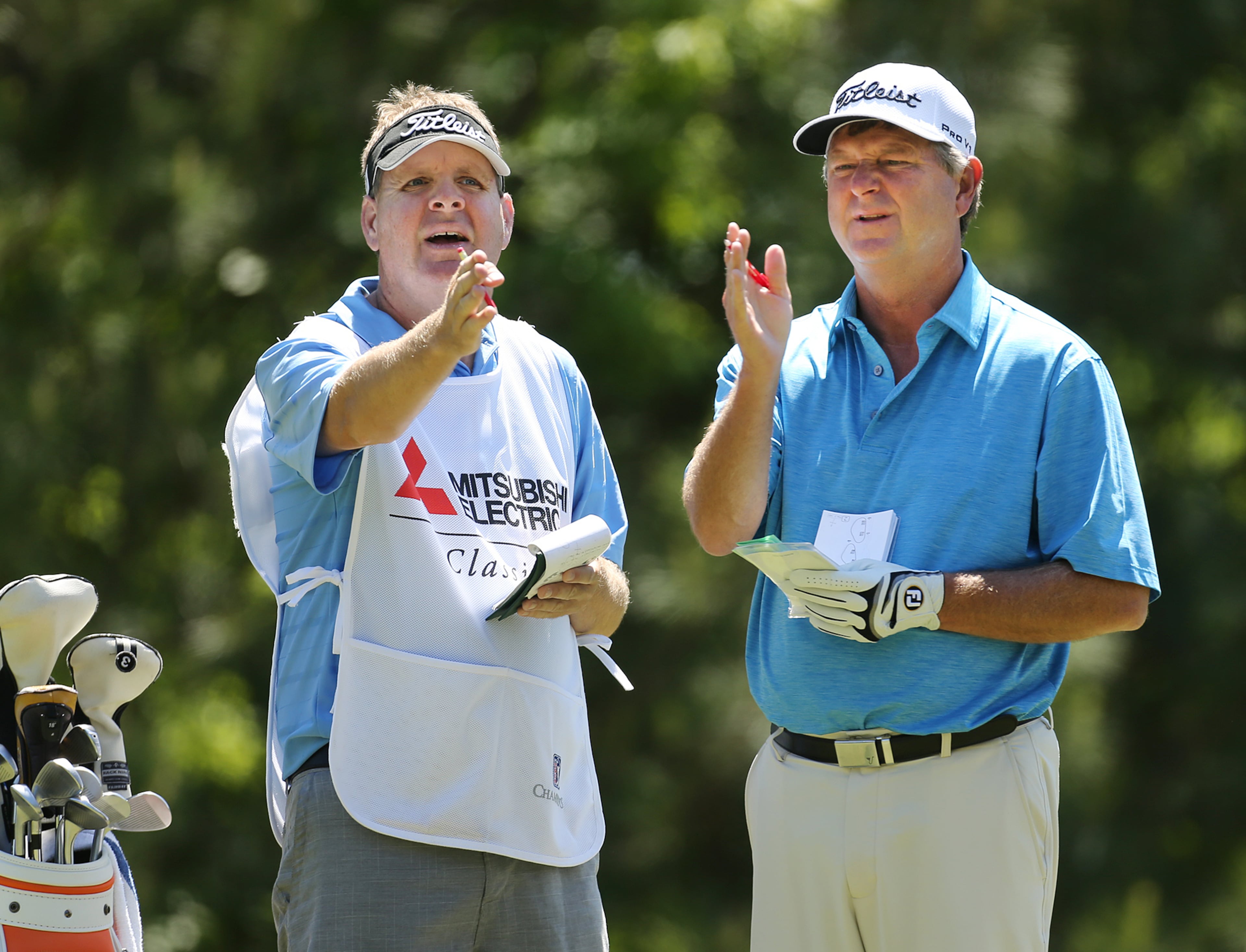 Wes Short, Jr., and his caddie check the wind on the second tee. Curtis Compton / ccompton@ajc.com