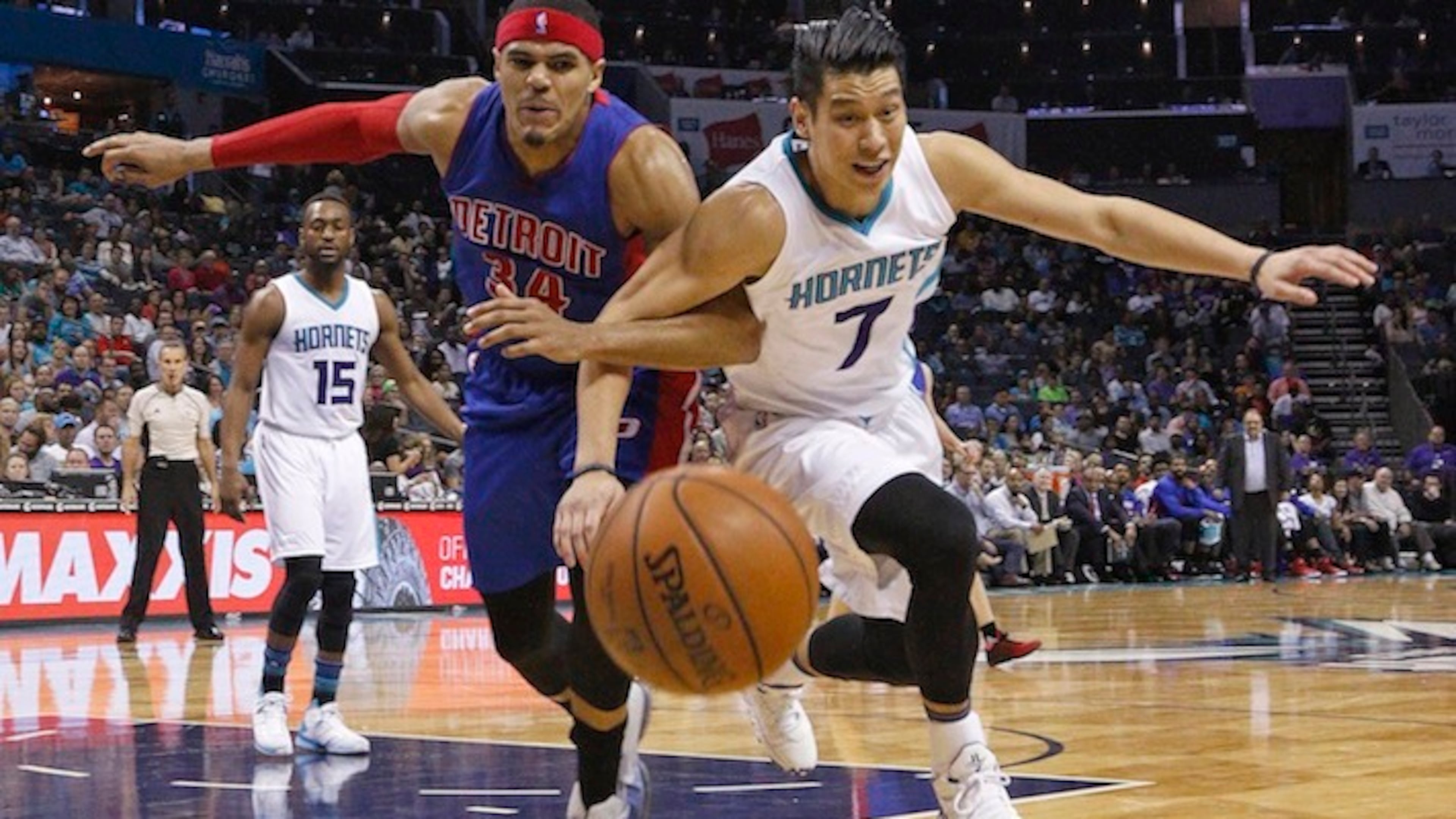 Detroit Pistons' Tobias Harris (34) and Charlotte Hornets' Jeremy Lin (7) chase down a loose ball arm-in-arm during the second half of an NBA basketball game in Charlotte, N.C., Friday, March 11, 2016. The Hornets won 118-103. (AP Photo/Bob Leverone)