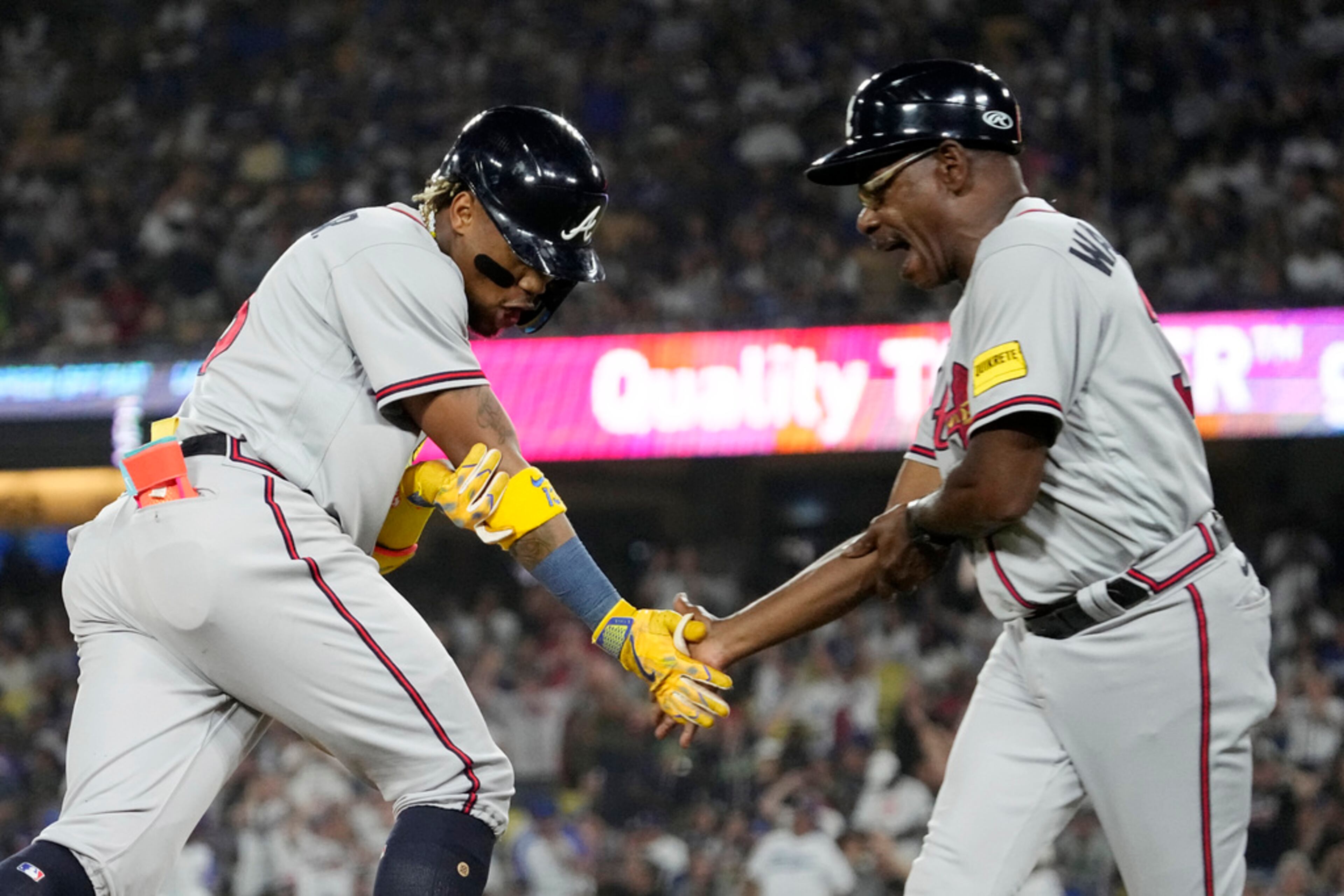 Atlanta Braves' Ronald Acuna Jr., left, is congratulated by third base coach Ron Washington after hitting a grand slam during the second inning of a baseball game against the Los Angeles Dodgers Thursday, Aug. 31, 2023, in Los Angeles. (AP Photo/Mark J. Terrill)