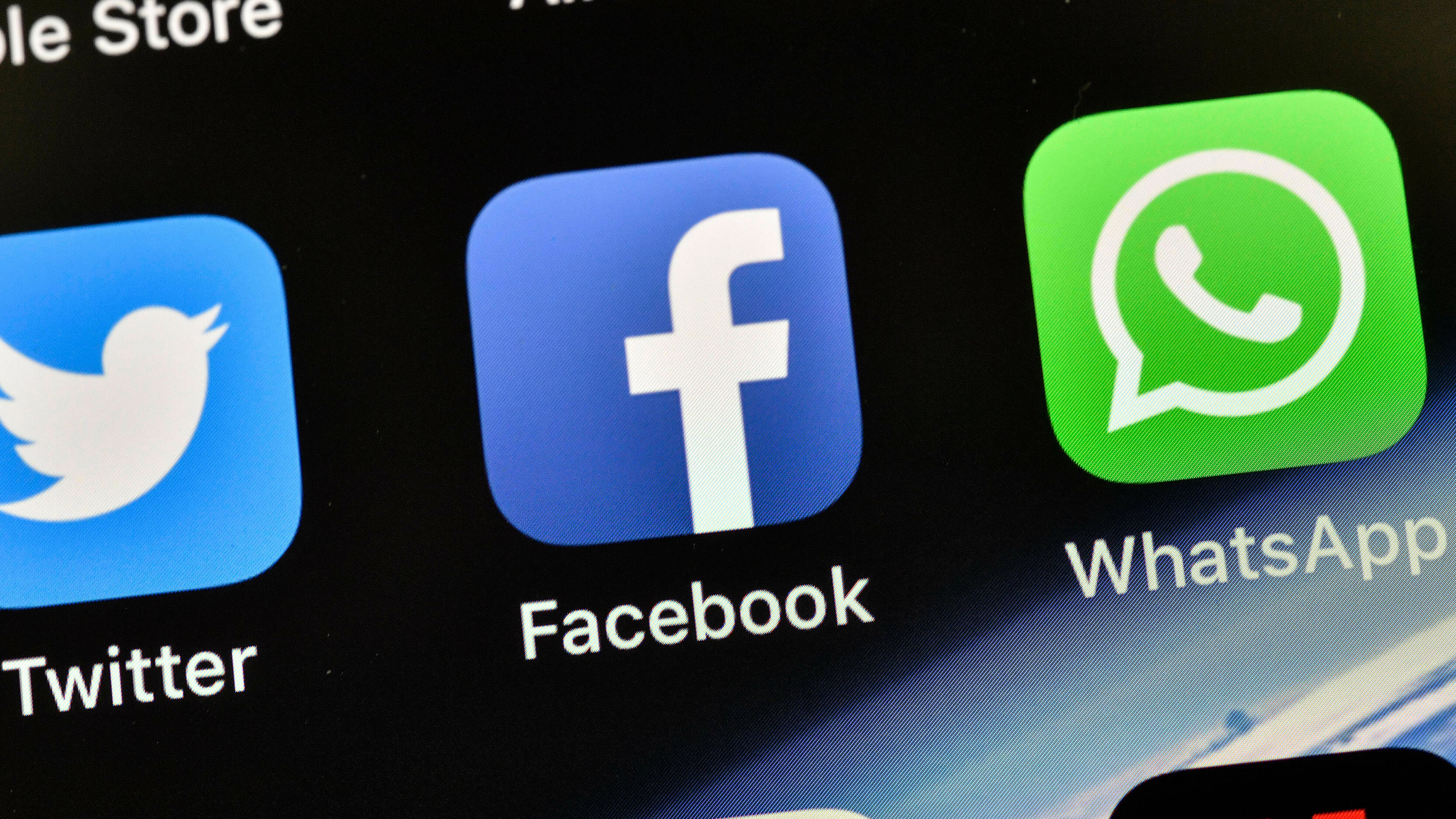FILE - In this Thursday, Nov. 15, 2018 file photo the icons of Facebook and WhatsApp are pictured on an iPhone in Gelsenkirchen, Germany. (AP Photo/Martin Meissner,File)