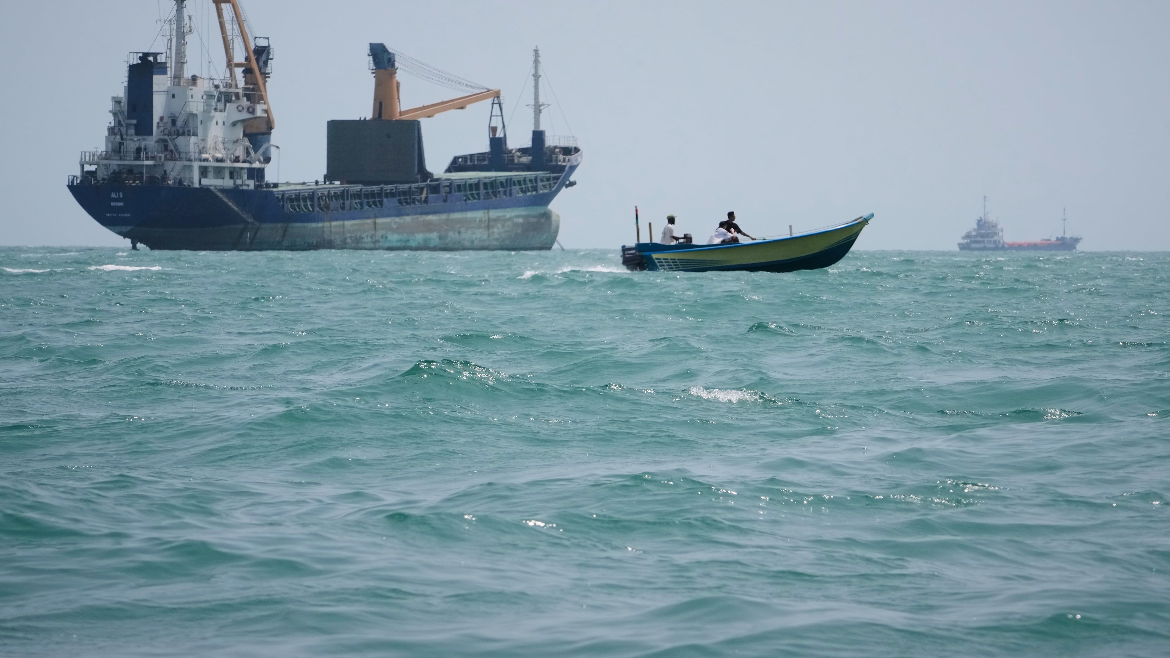 A motorboat passes a general cargo ship anchored in the Strait of Hormuz off Bandar Abbas, Iran, Sunday, Sept. 6, 2026. (AP Photo/Vahid Salemi)